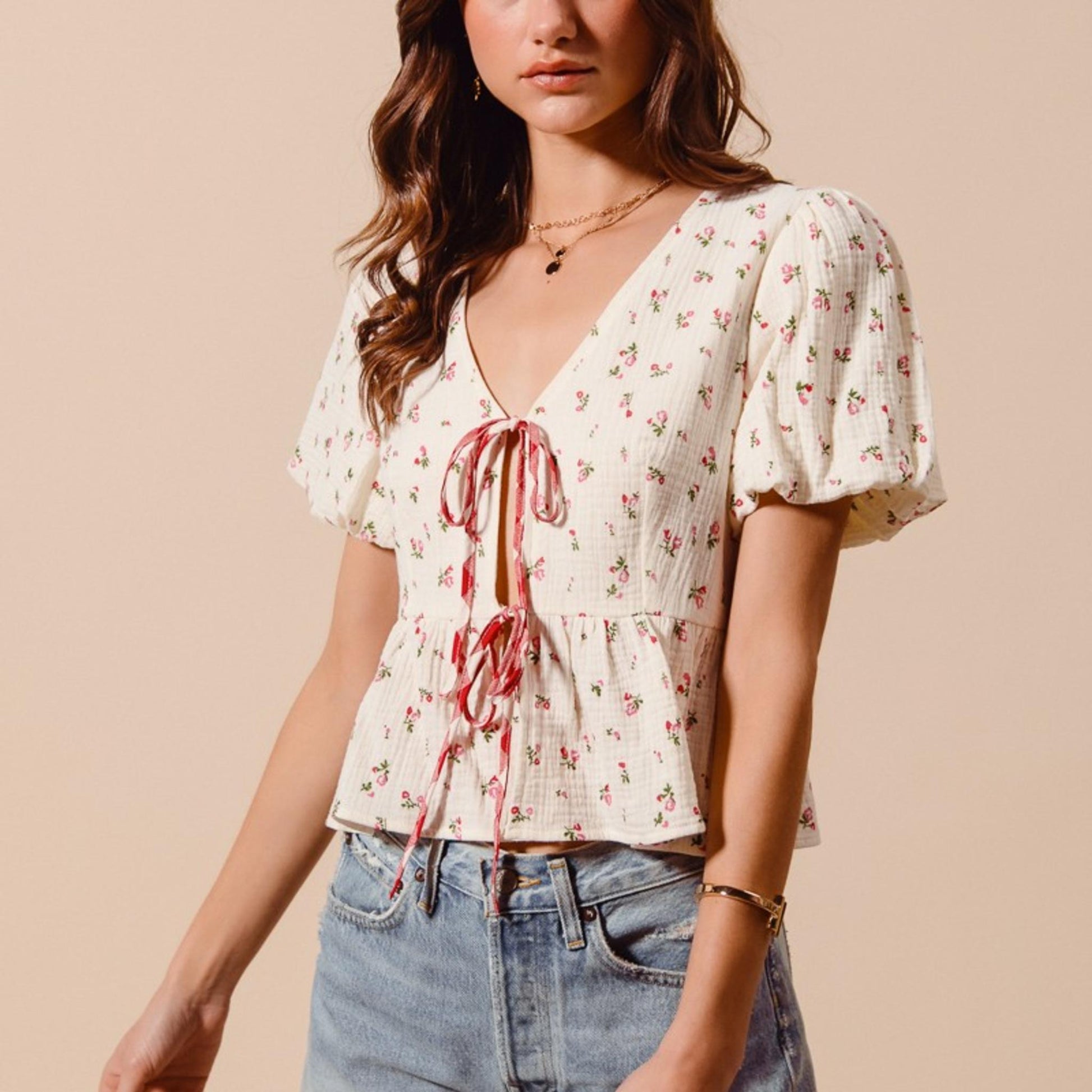 Close-up view of the intricate ditsy floral print and lightweight gauze fabric on the ivory red check blouse.