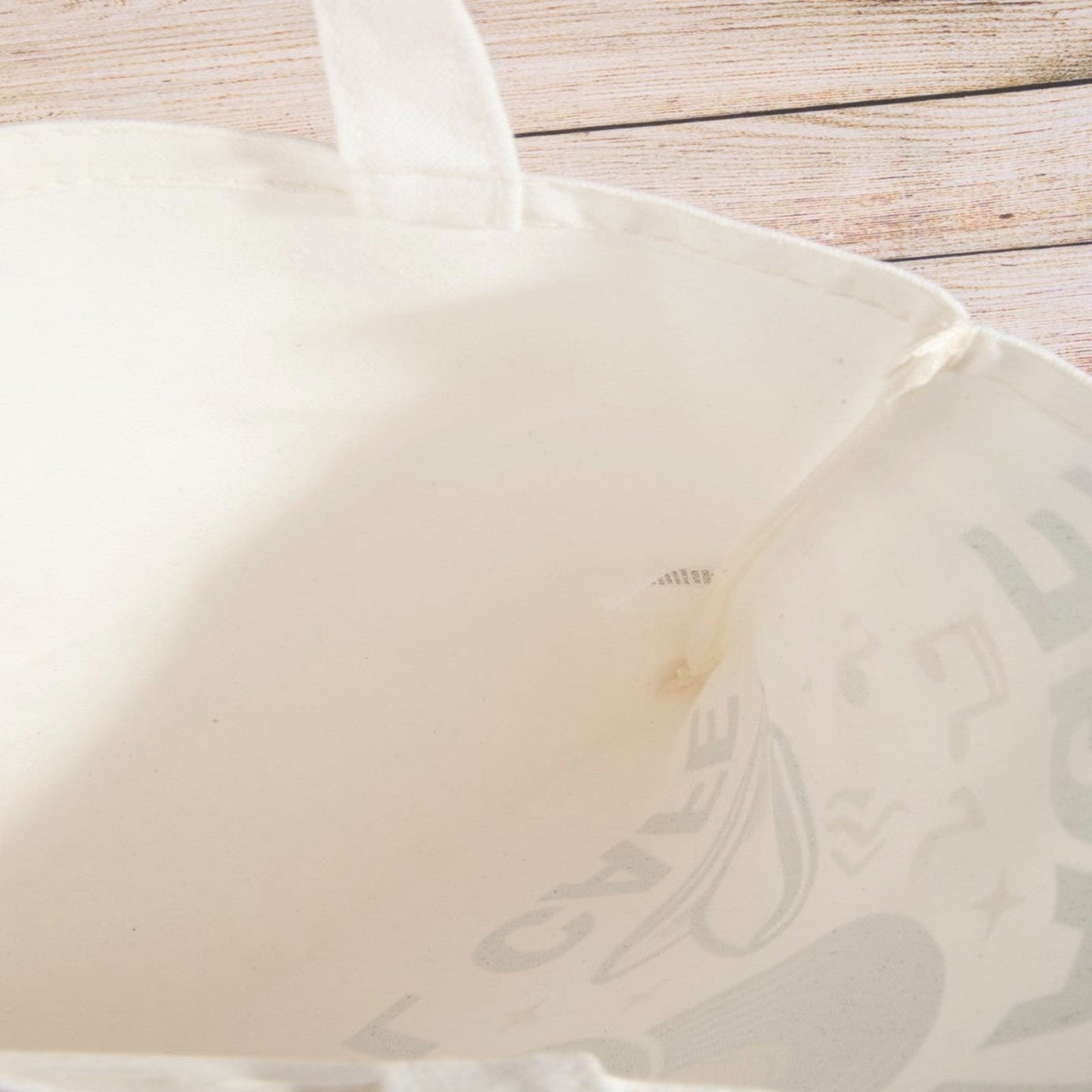 View of the roomy interior and lightweight fabric of the vinyl cafe tote bag