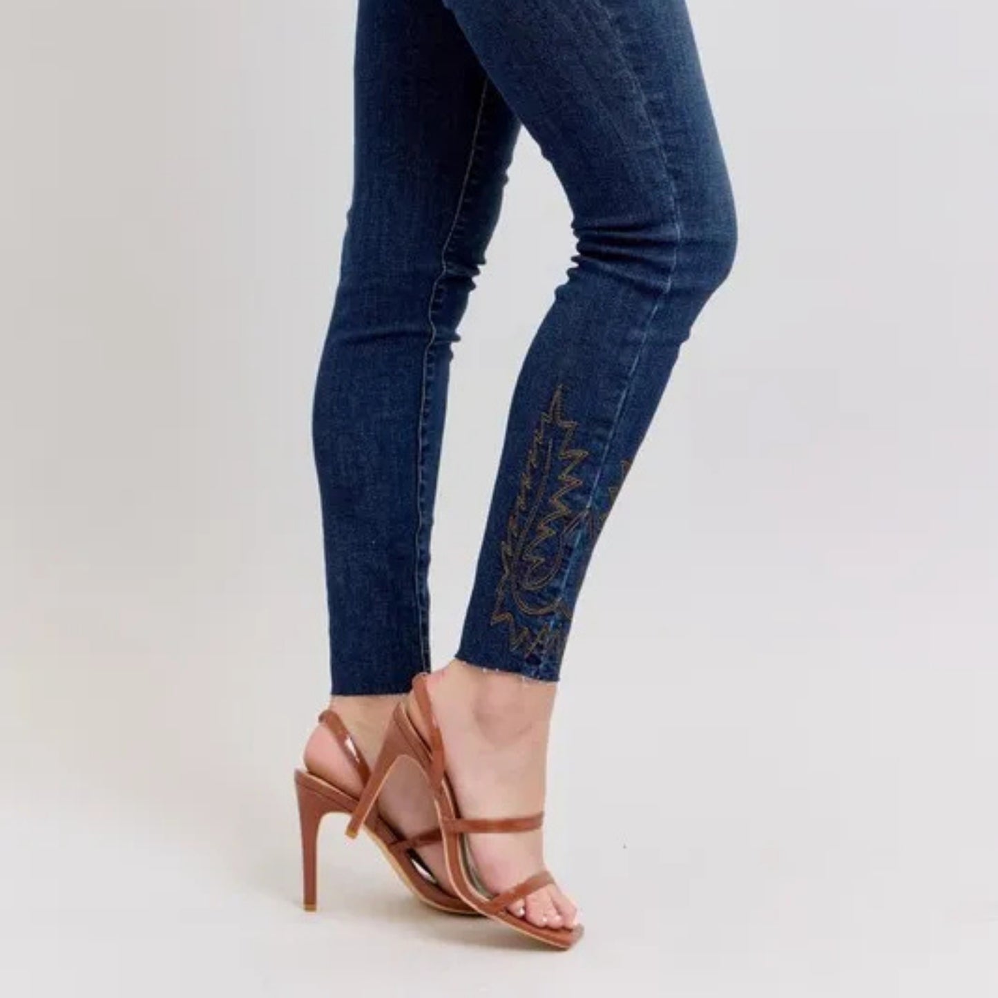 Close-up view of the intricate floral embroidery on the denim pockets.