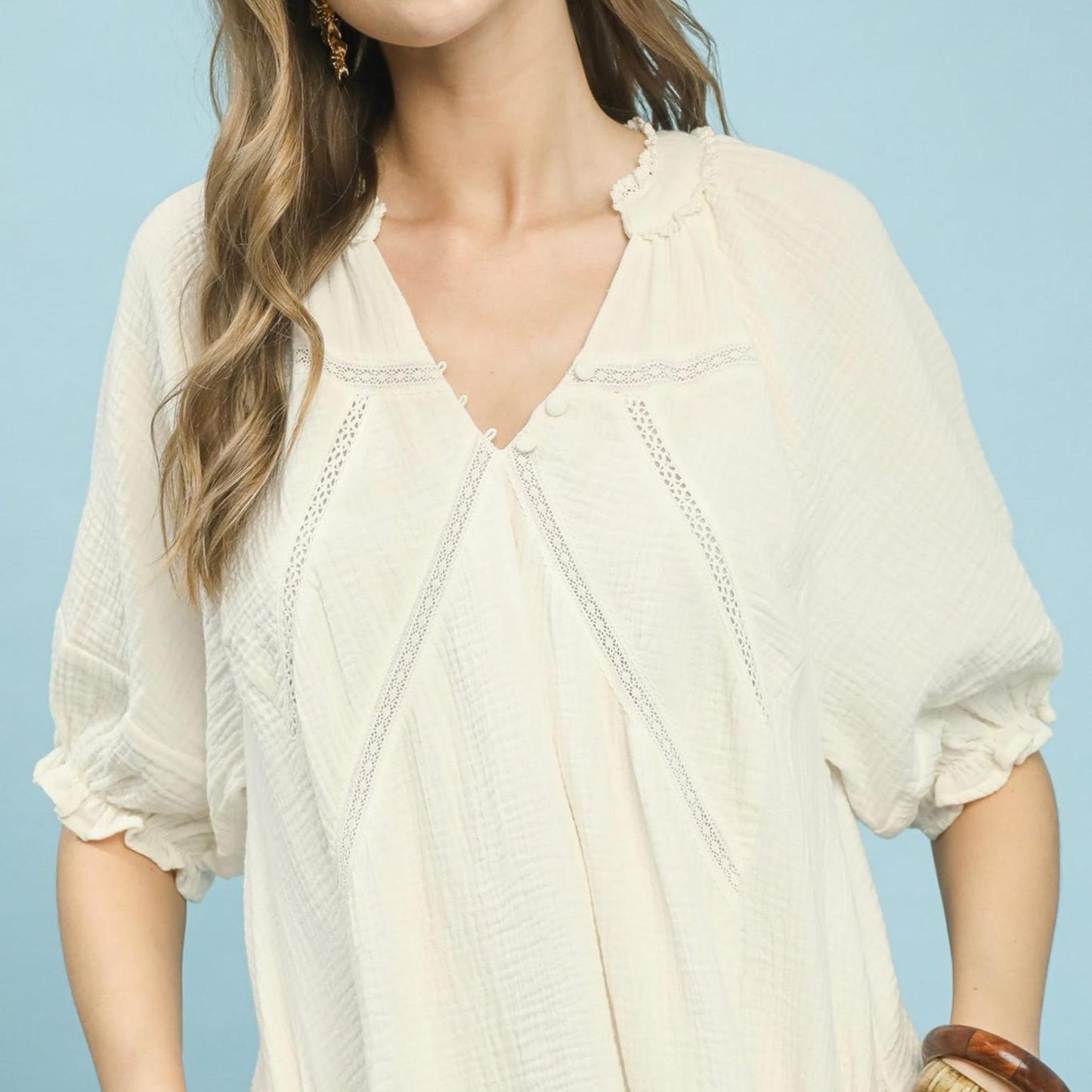 Woman wearing a white blouse against a light blue background