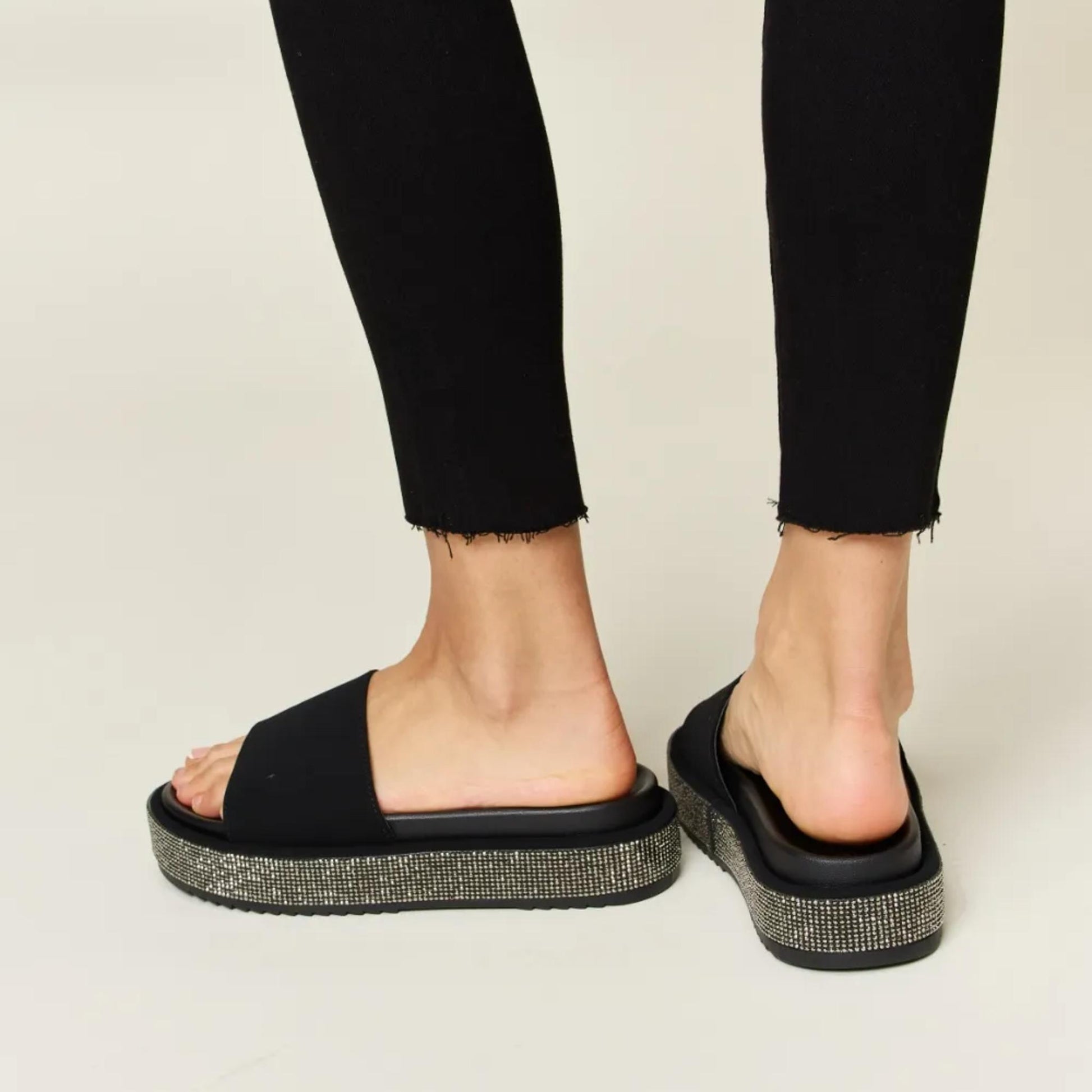 Detailed view of the comfortable cushioned footbed on the silver rhinestone platform sandals.