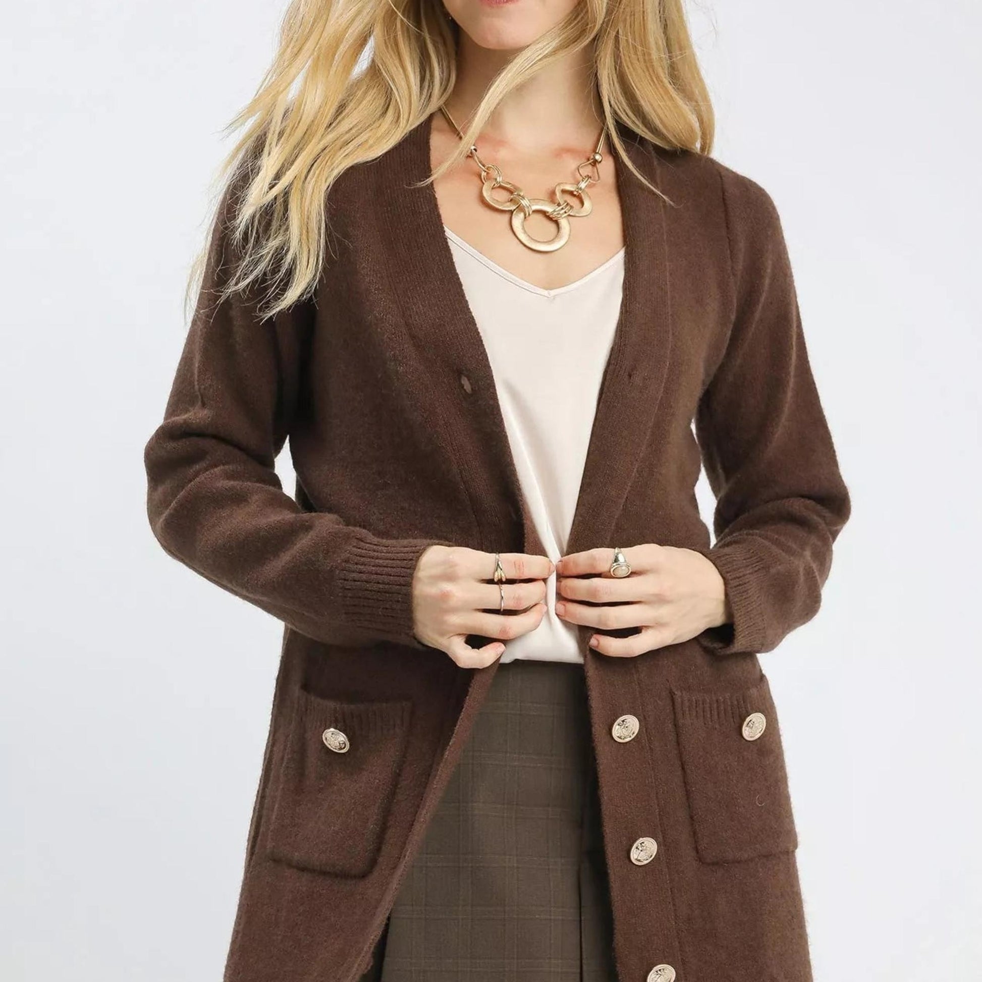 Detail shot of the functional front pockets and wide ribbed trim on a brown longline button-down cardigan.