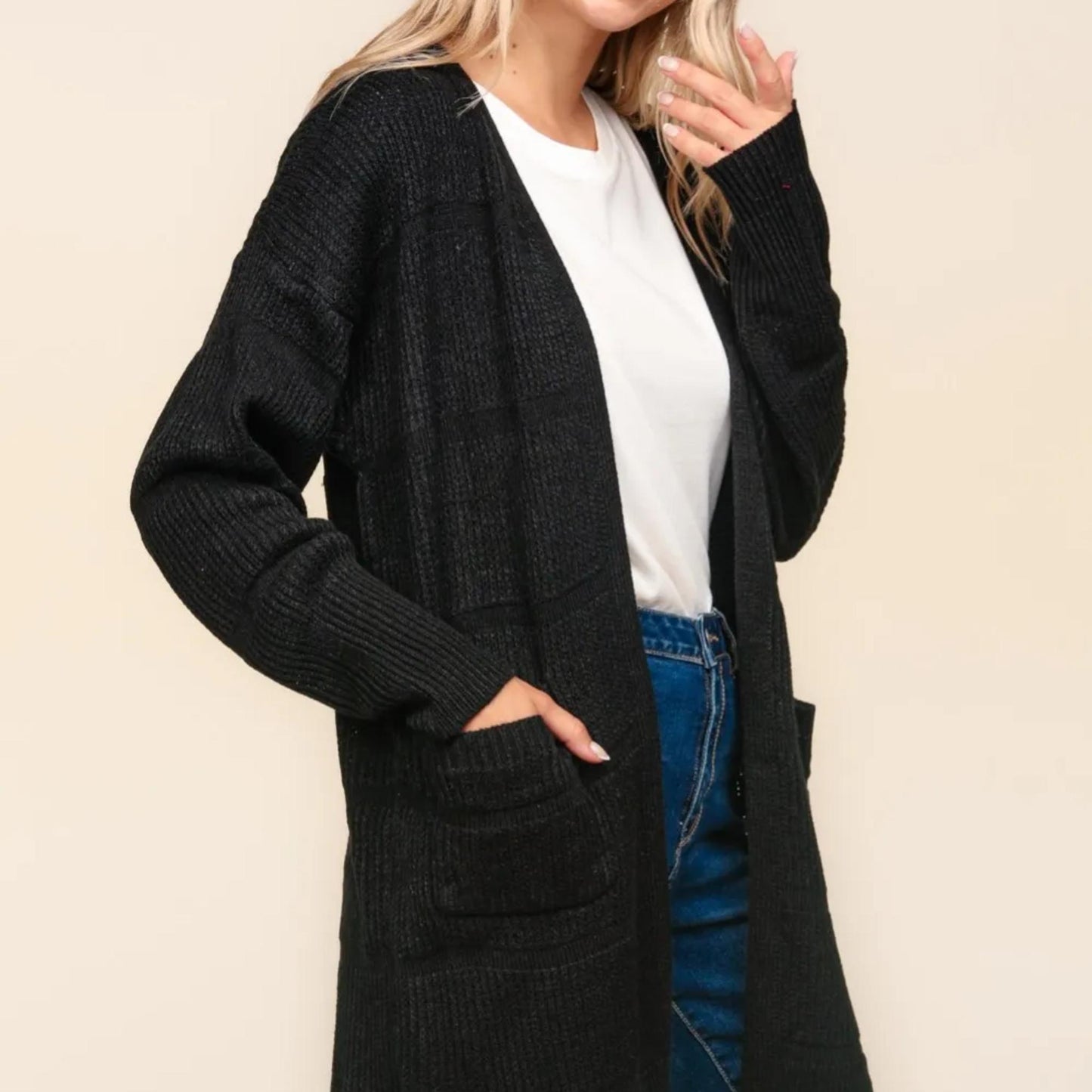 Detail view of the functional front pockets on the solid black Haptics cardigan.