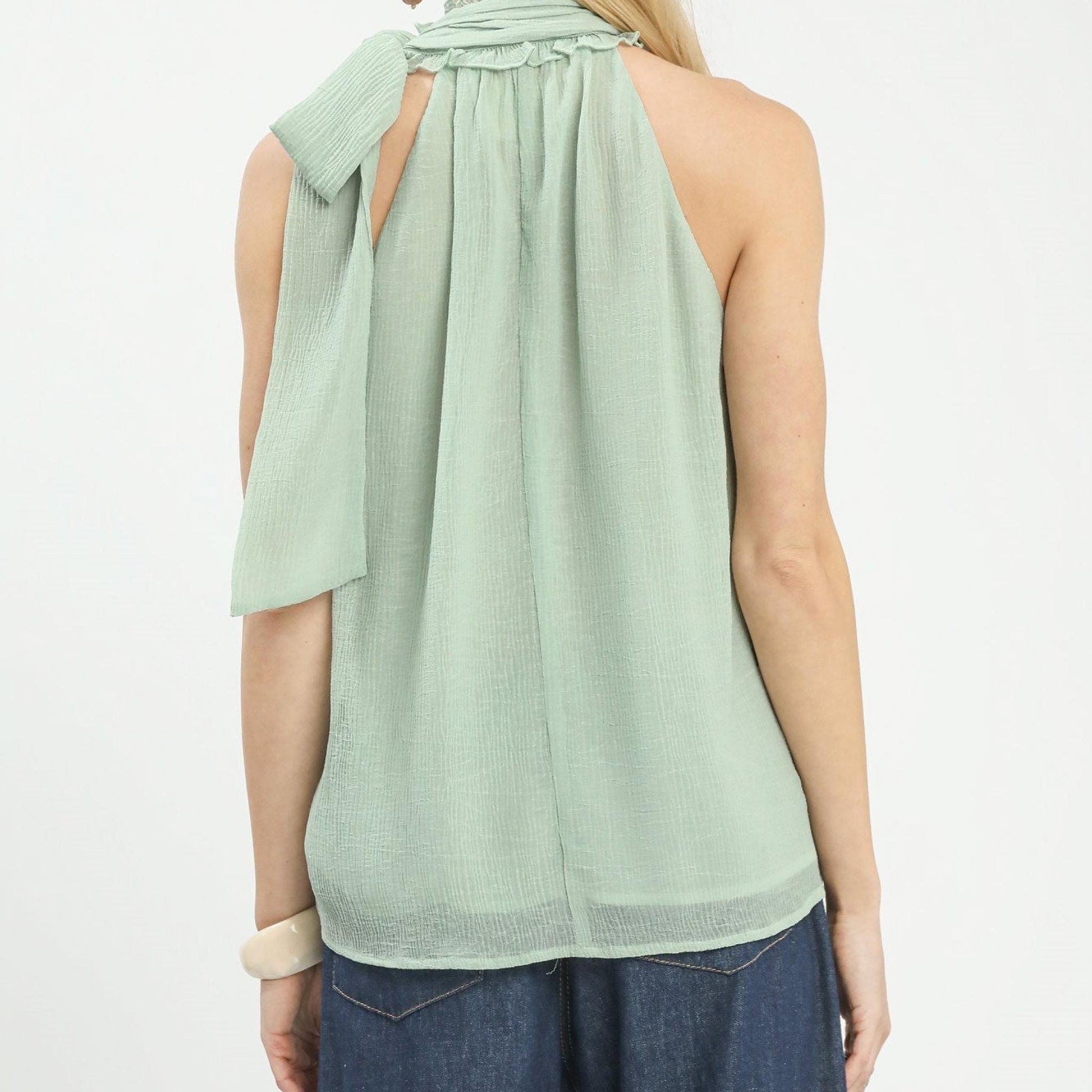 Detailed texture shot of the lightweight mint chiffon fabric used in the Umgee halter top.