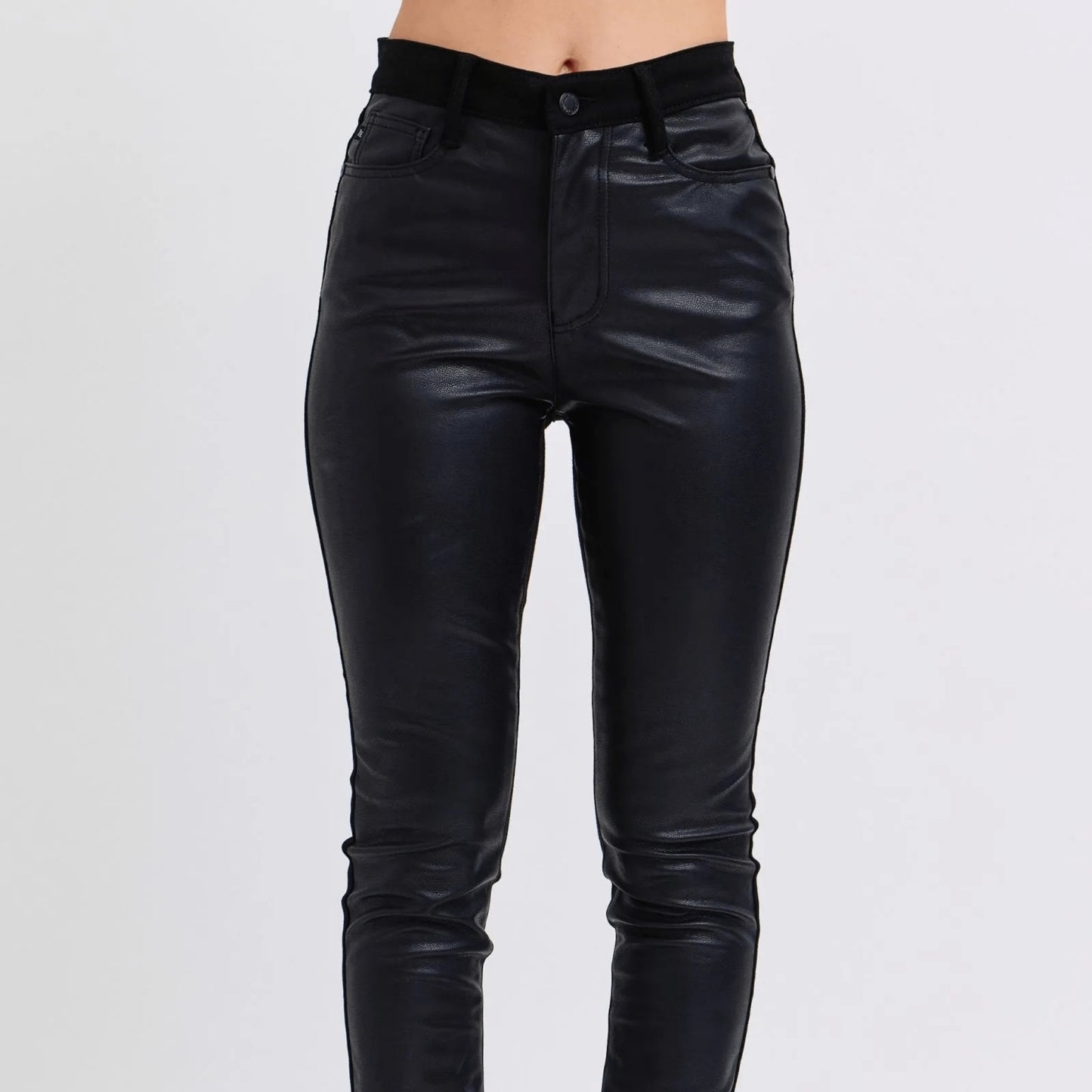 Front view of black faux leather skinny pants highlighting the sculpting high-rise fit.