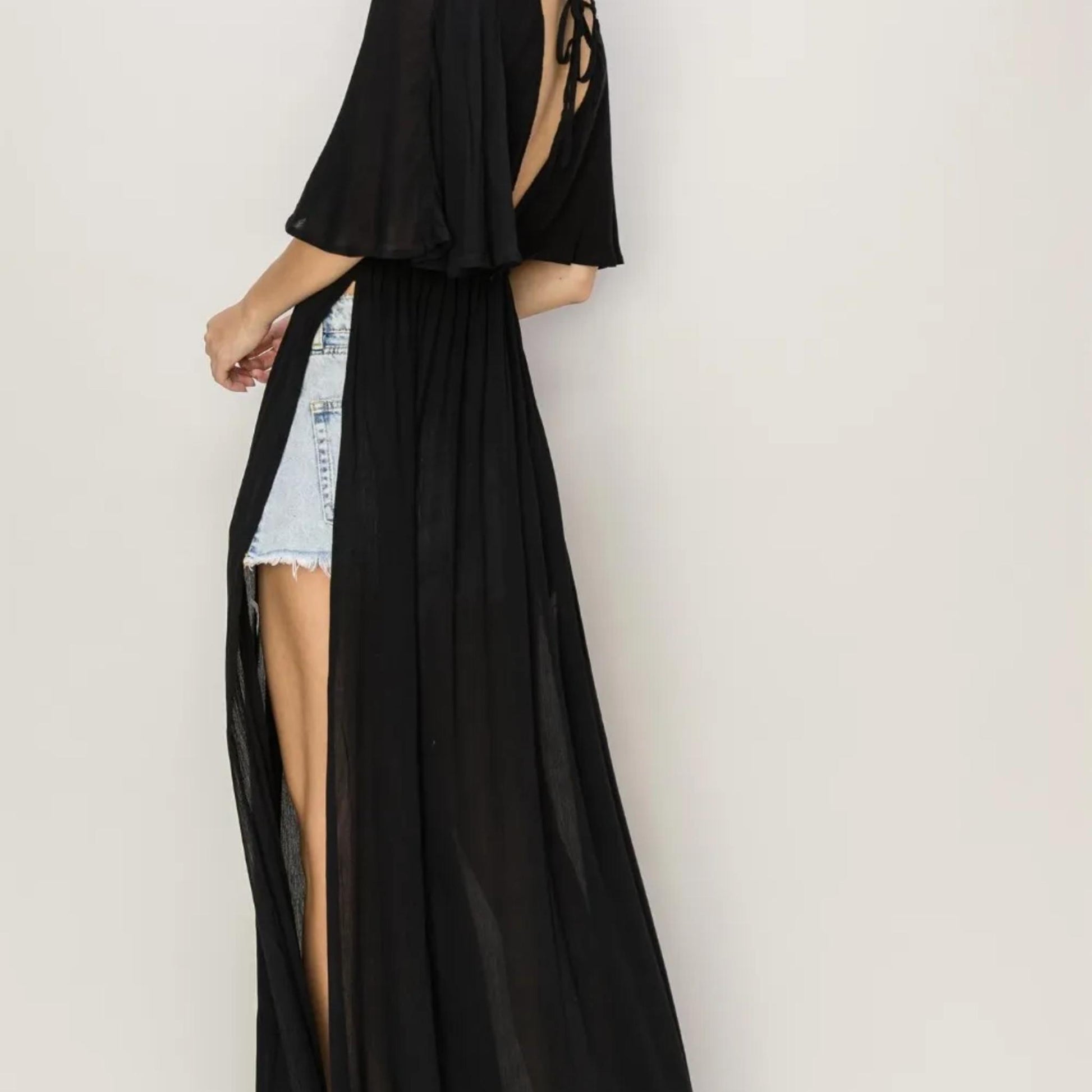 Showcasing the low side slits and flowy movement of the HYFVE Black cover up dress.