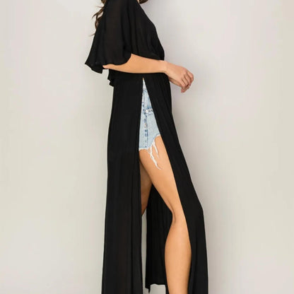 Showcasing the high side slits and flowy movement of the HYFVE Black cover up dress.