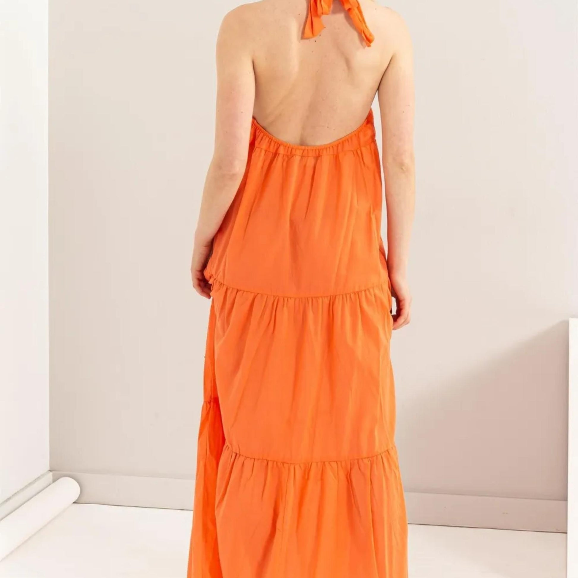 Back view showing the open back and tie-neck detail on the HYFVE Orange dress.