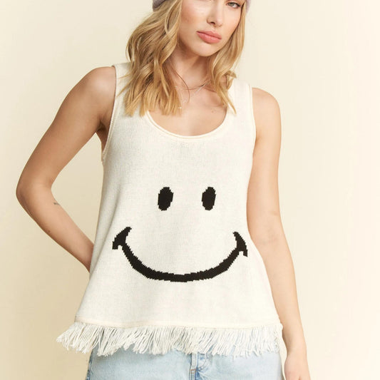 Front view of the Jade By Jane cream smiley face fringe tank with denim shorts.