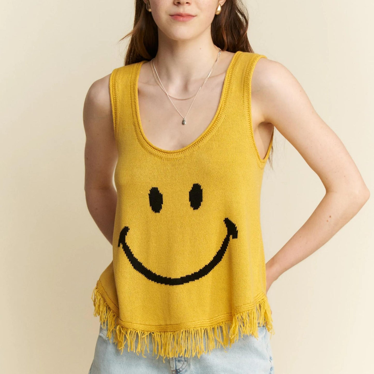 Front view of the Jade By Jane mustard yellow smiley face fringe tank.
