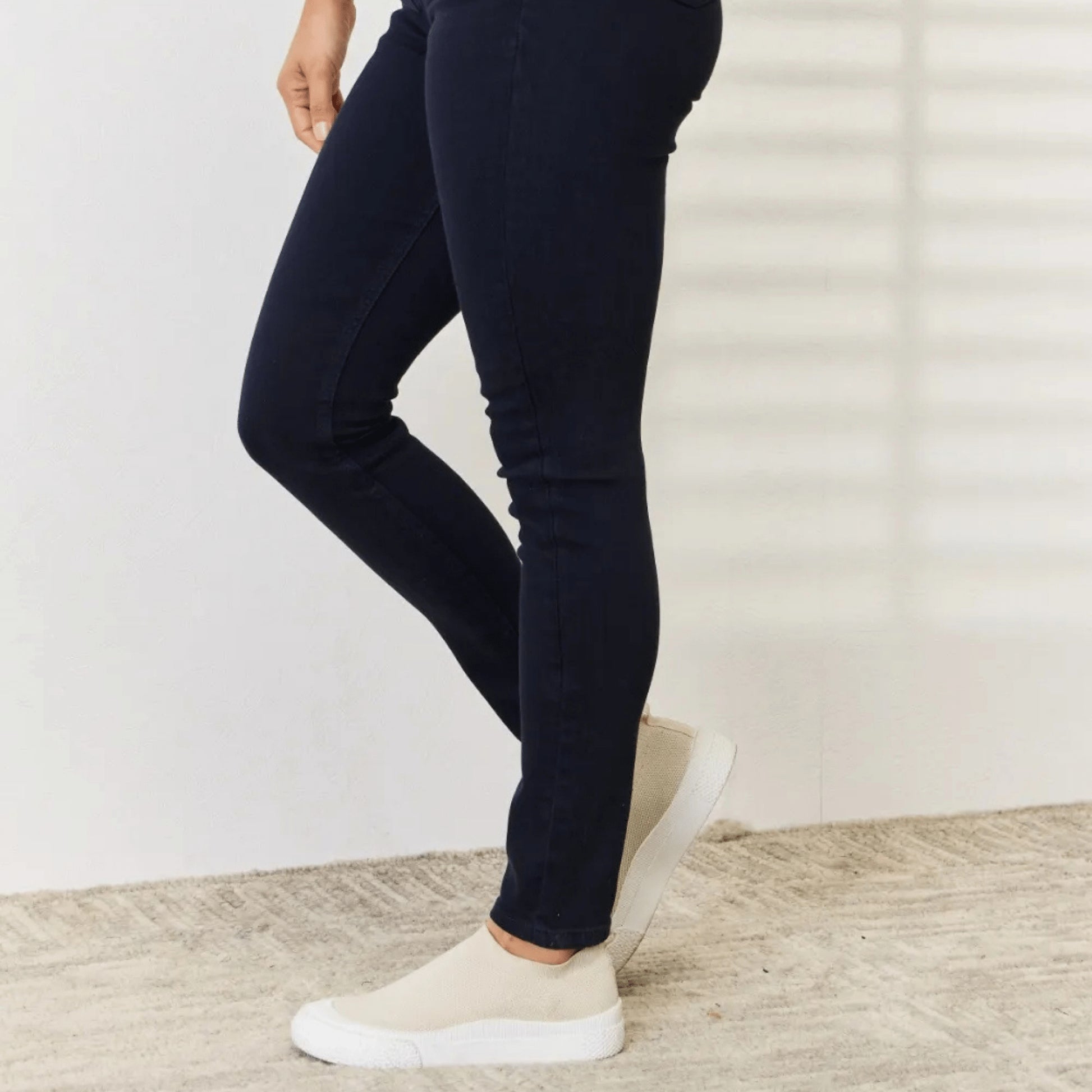 Side view showcasing the slimming fit of the navy skinny jeans.