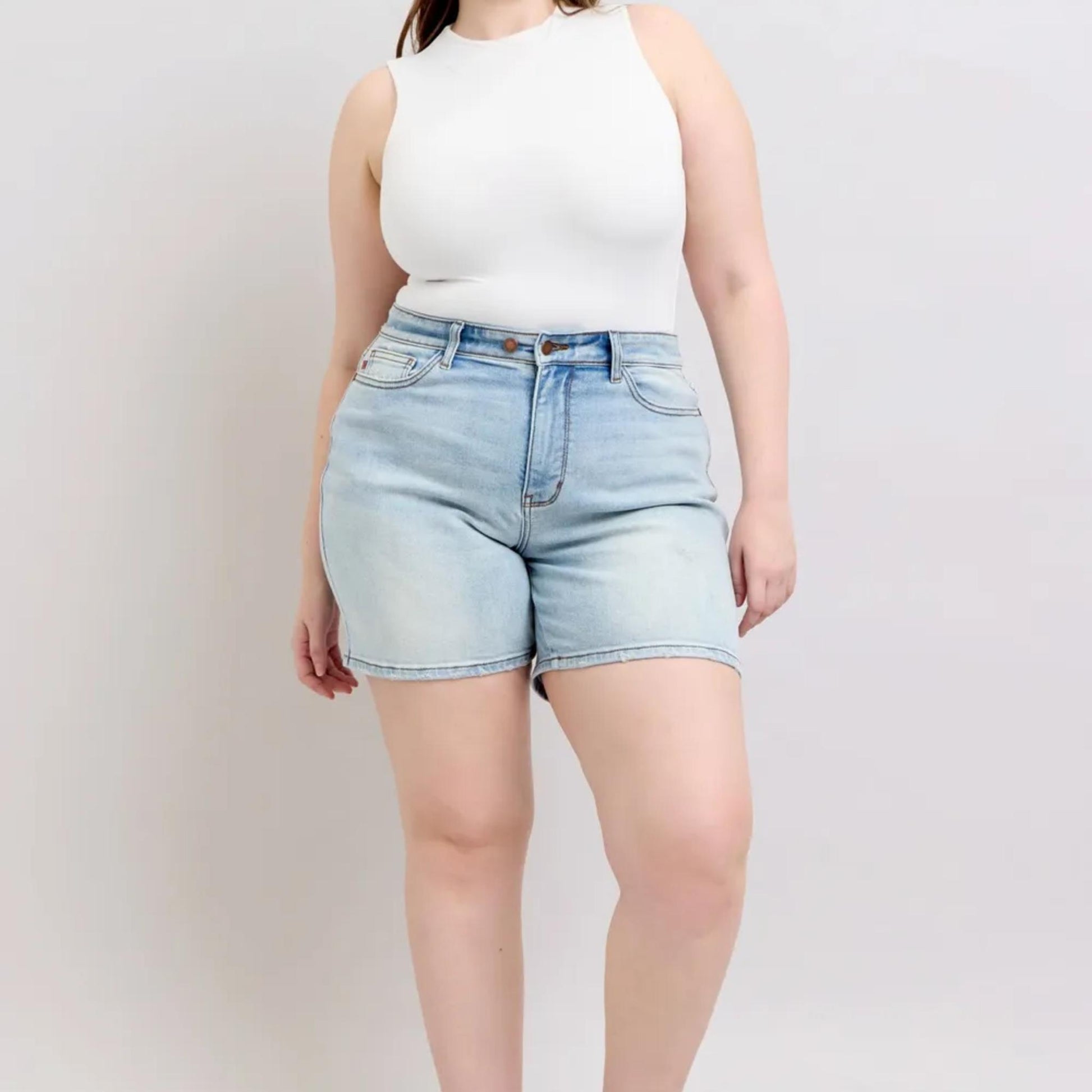 Detailed view of the 2-button closure on the light wash denim shorts.