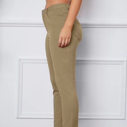 Khaki pants worn by a person against a white wall
