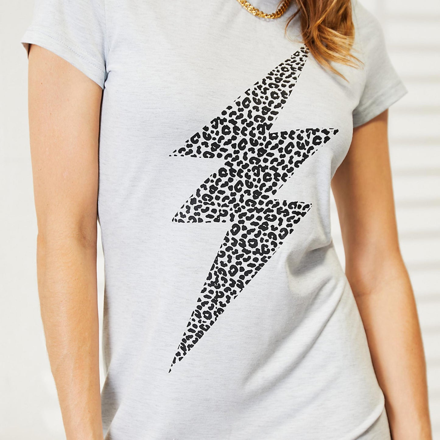 Detailed close-up of the black leopard print lightning bolt design on the light gray fabric.
