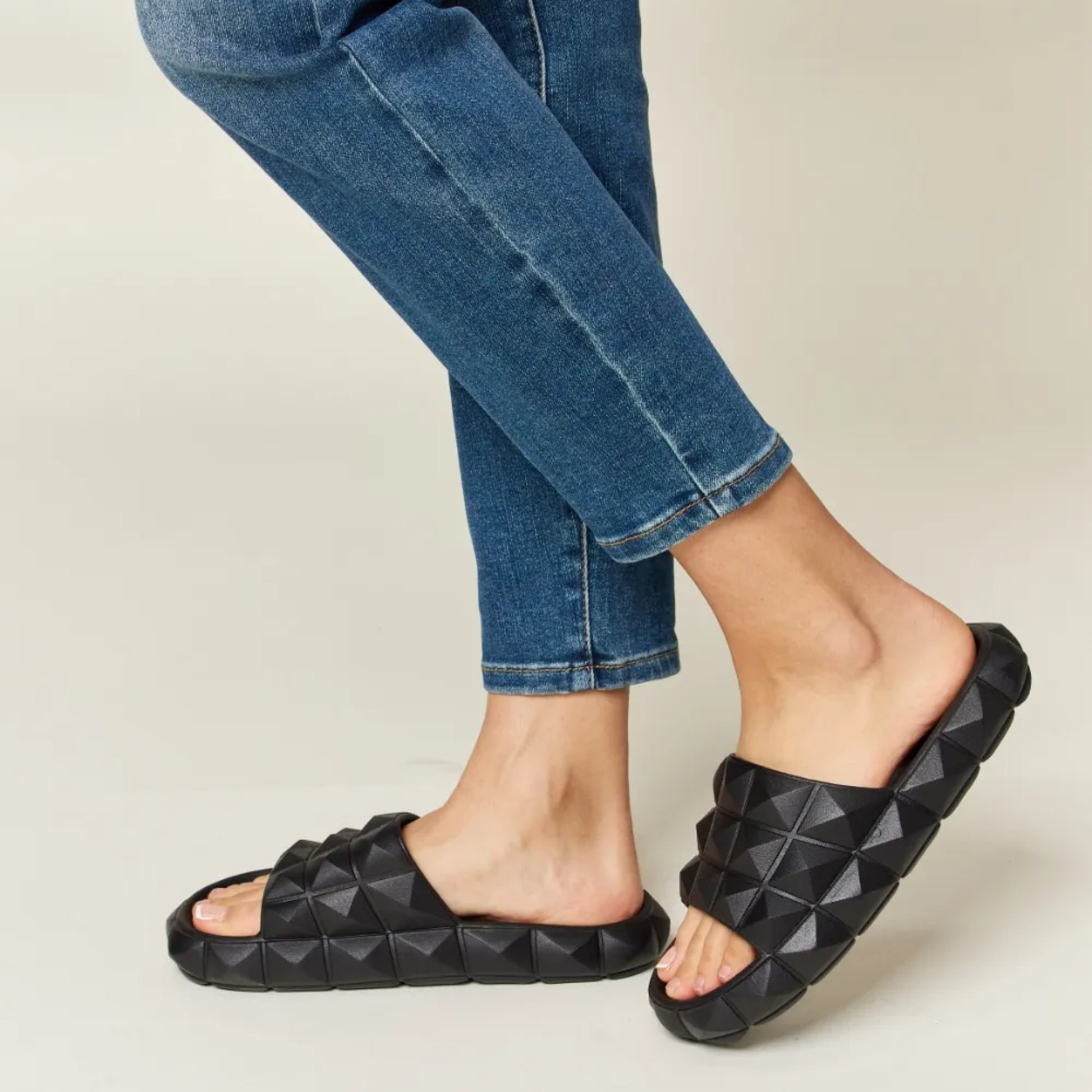 Lifestyle shot of the studded sandals styled for a bold, modern summer outfit.