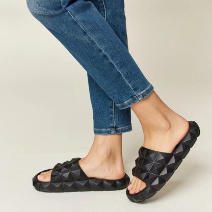 Lifestyle shot of the studded sandals styled for a bold, modern summer outfit.