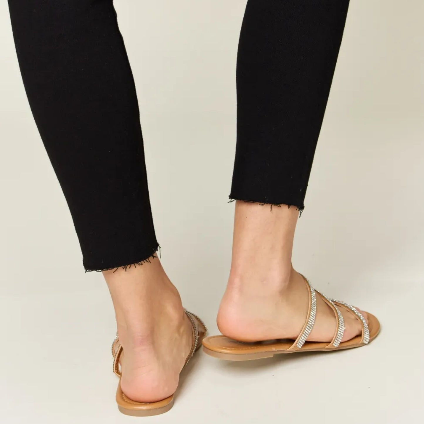Lifestyle shot of the tan rhinestone sandals styled for a bright summer day.