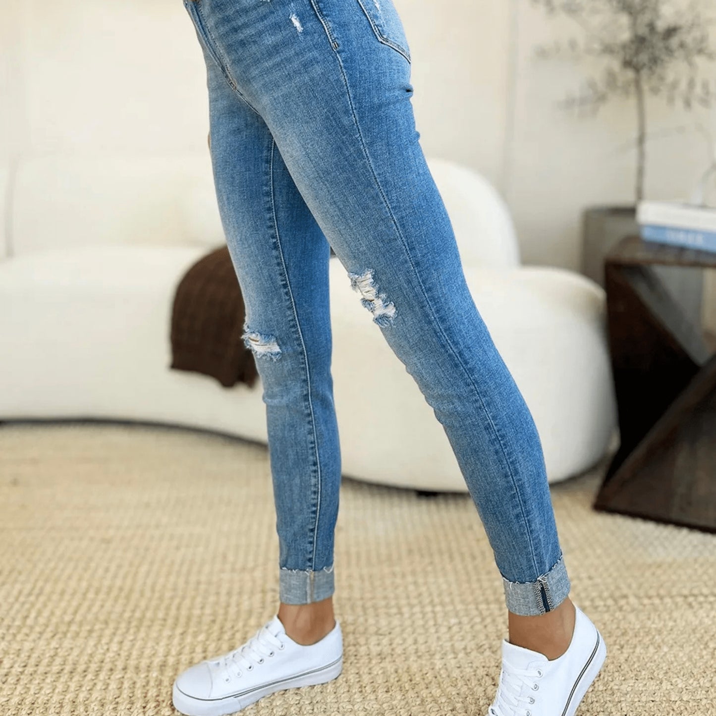 Detailed front view of mid-rise skinny jeans with cuffed ankles.