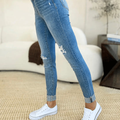 Detailed front view of mid-rise skinny jeans with cuffed ankles.
