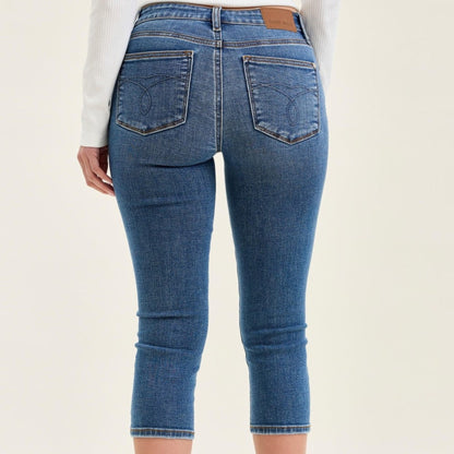 Back view of mid-rise capri jeans showing functional pockets and slim fit silhouette.