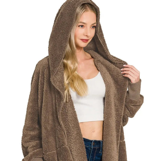 Detailed view of the attached hood and front pockets on the mocha faux fur jacket.