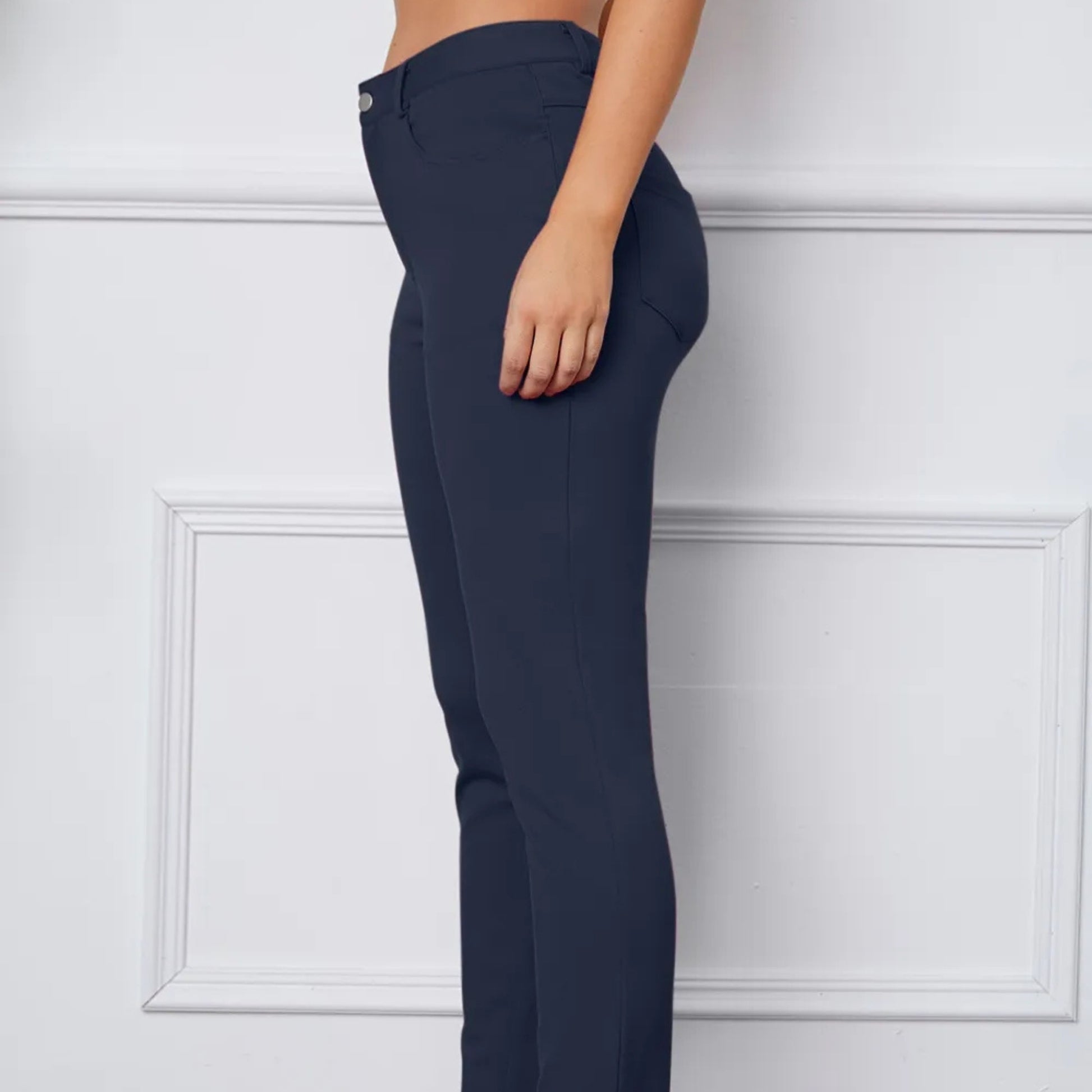Navy blue pants worn by a person on a white background