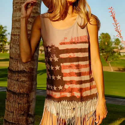 Person wearing a tank top with an American flag design and fringe details, standing outdoors.
