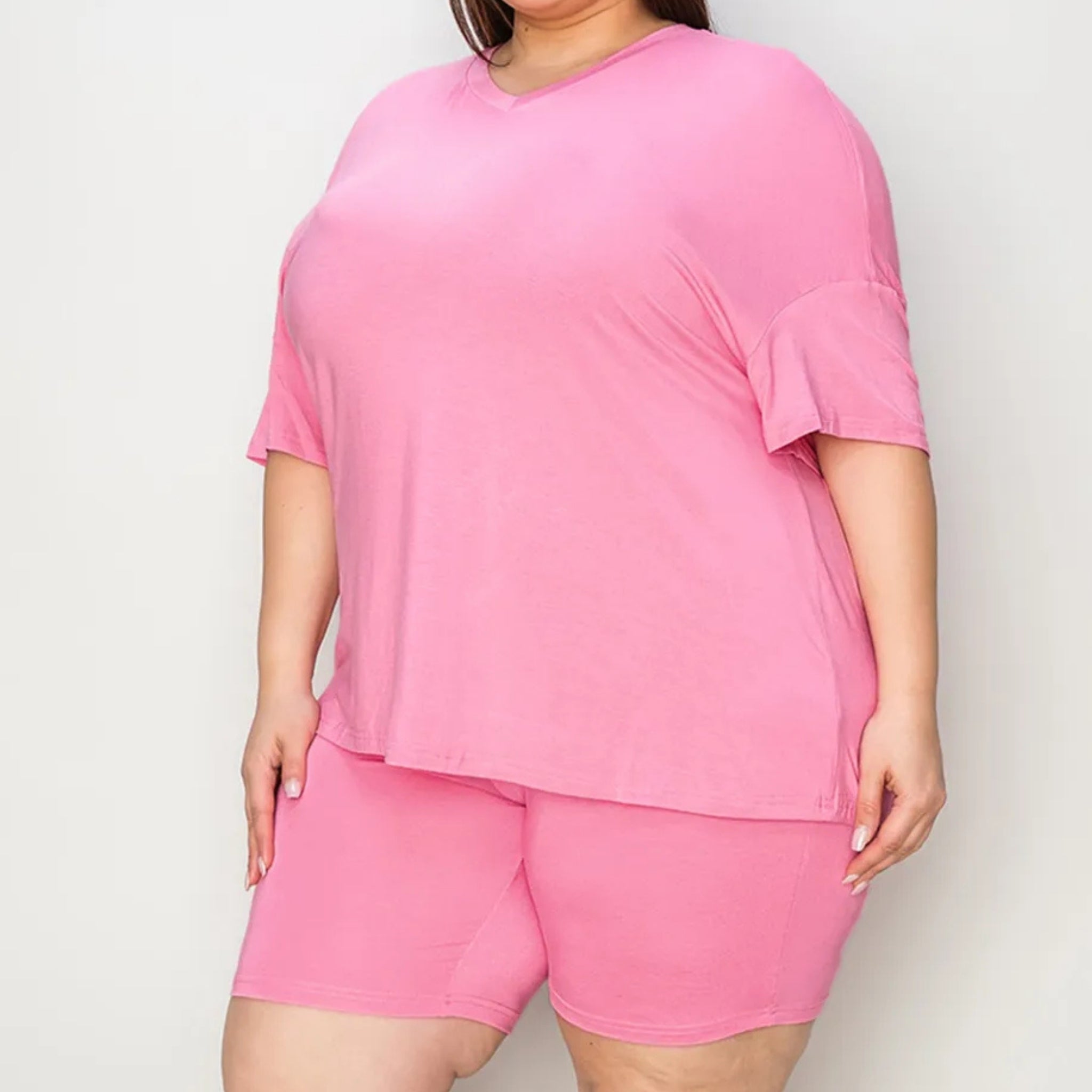 Oversized  Person wearing a pink outfit with a top and shorts on a plain background