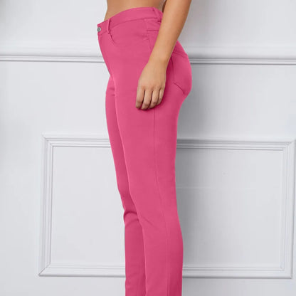 Pink pants worn by a person against a white wall