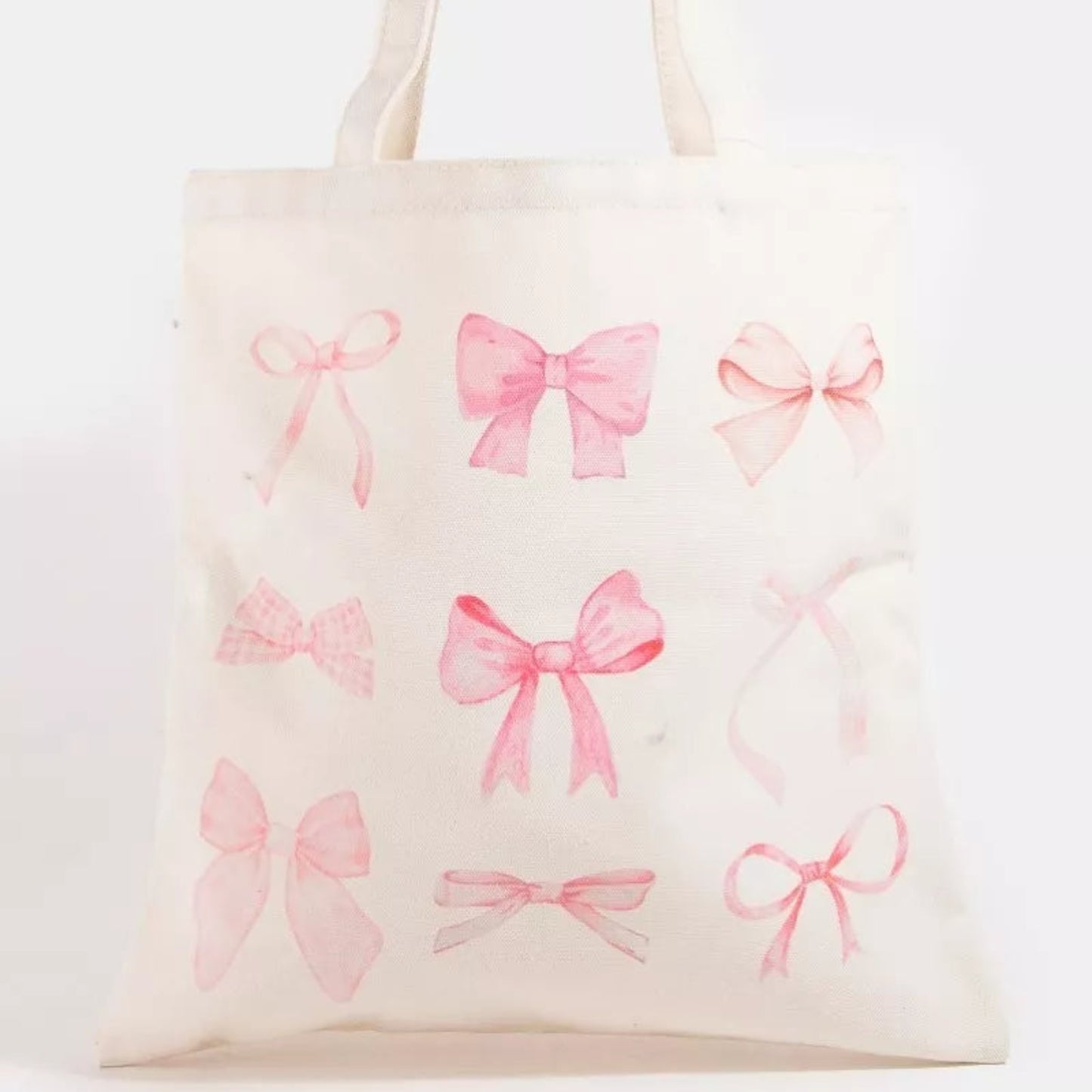 Pink ribbon bow tote bag with a sweet pink bow design and sturdy white shoulder straps