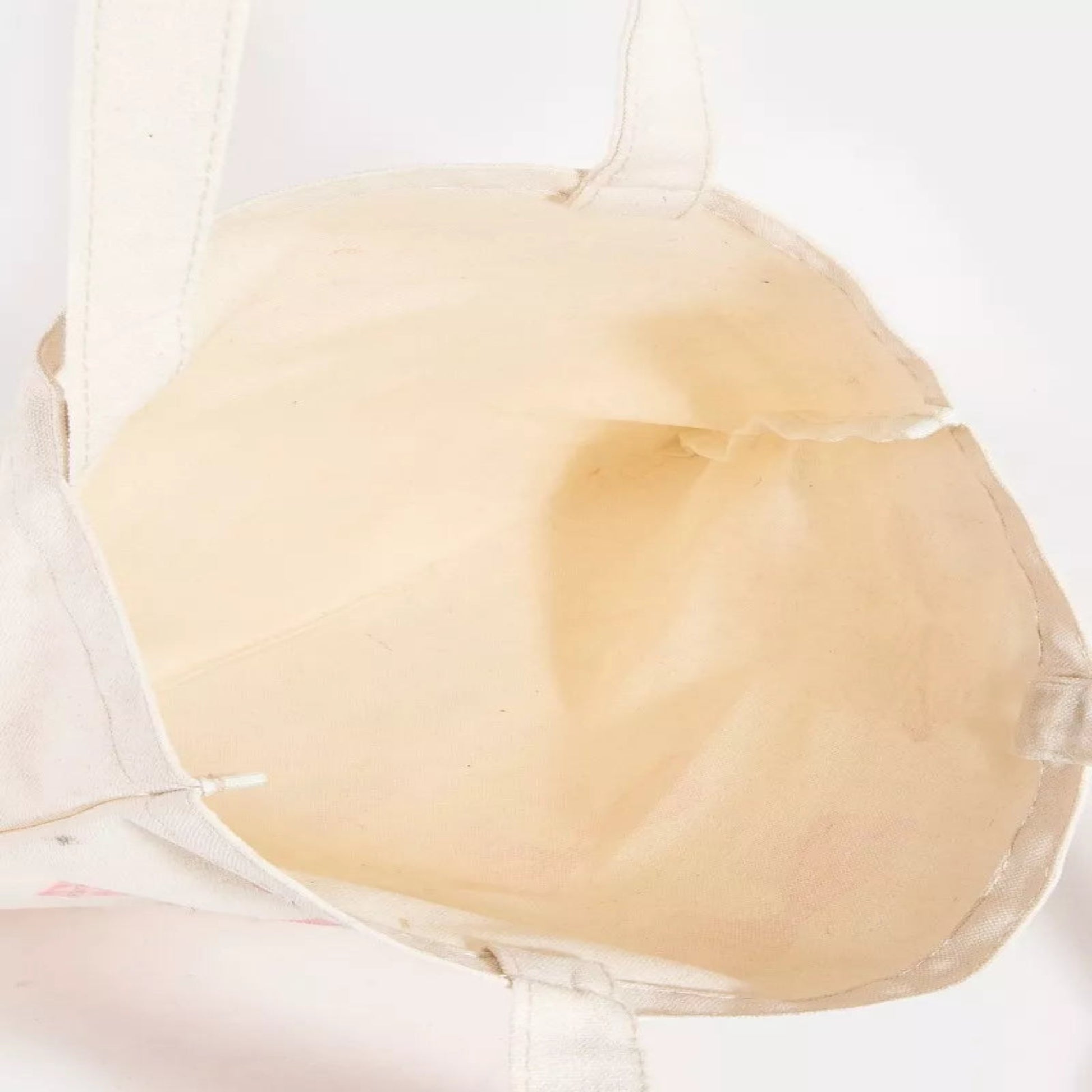 Roomy interior of the pink ribbon bow tote bag showing space for phones and cosmetics