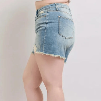 Close-up of the fly stitch detail and distressed elements on high-rise denim shorts.