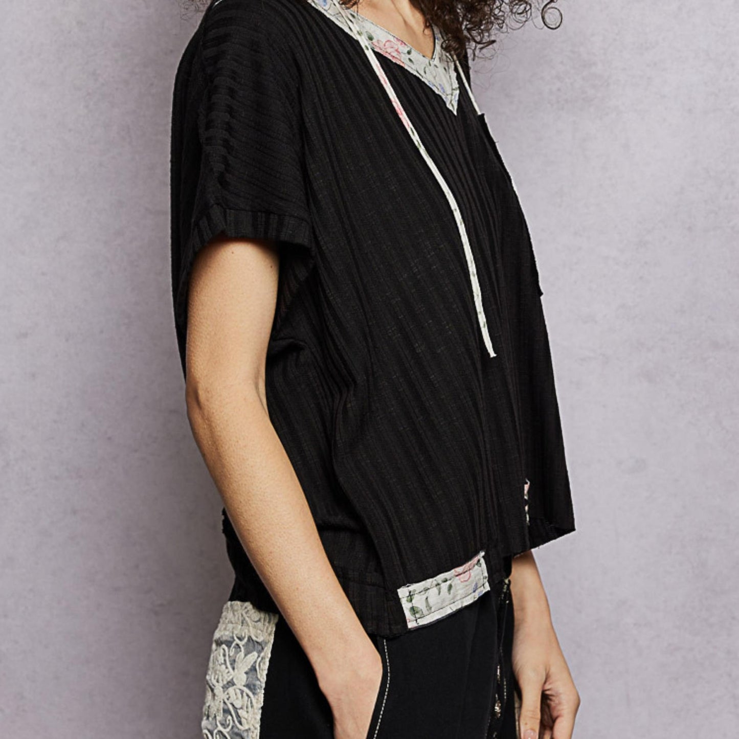 POL black short sleeve hooded top with relaxed fit — side perspective.