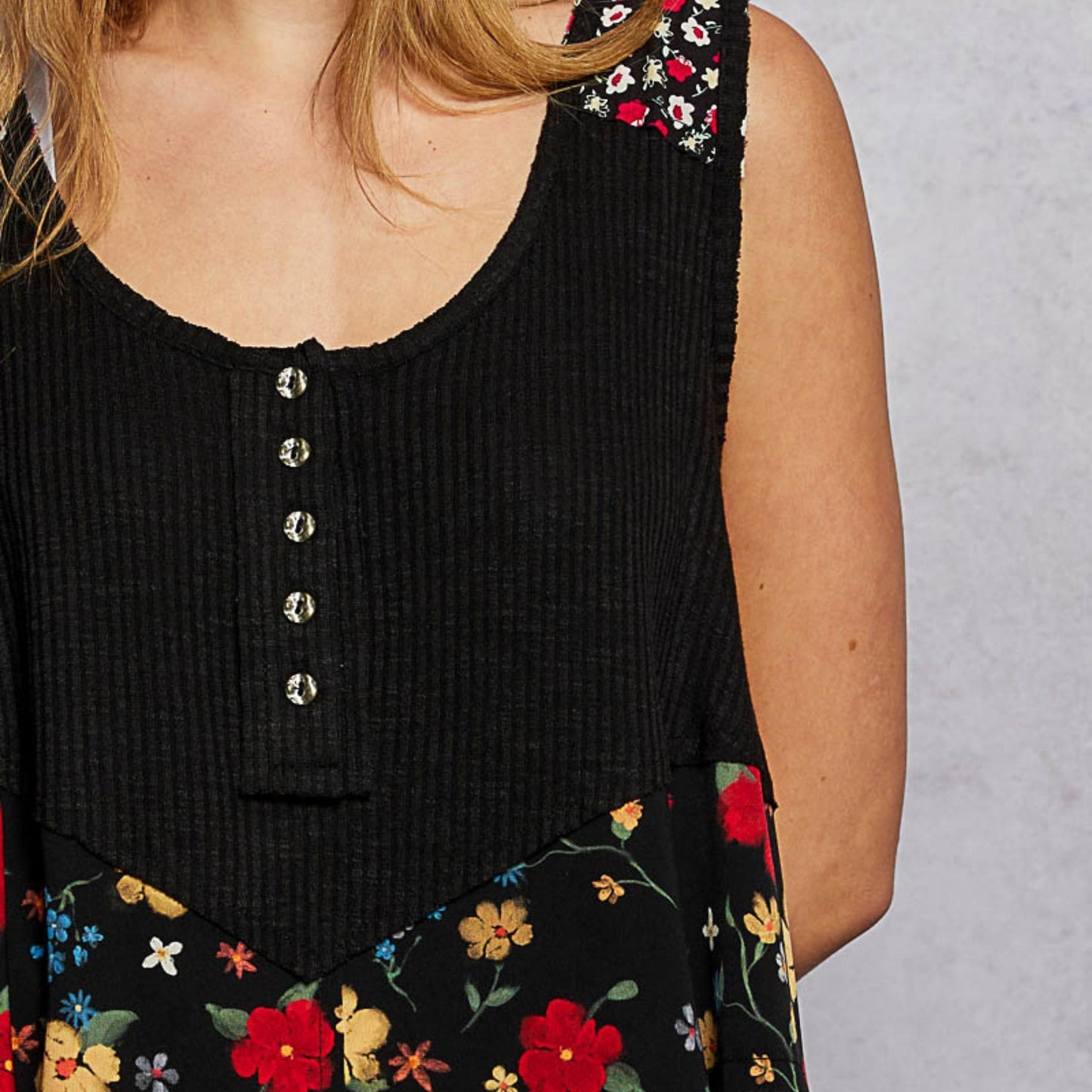 Close-up of the woven floral patch and rustic metal buttons.