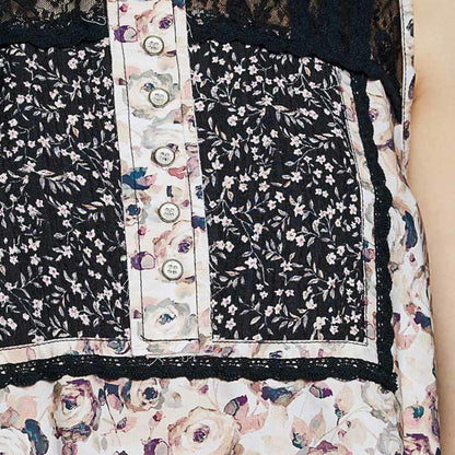 Close-up of a floral dress with black lace trim and buttons.