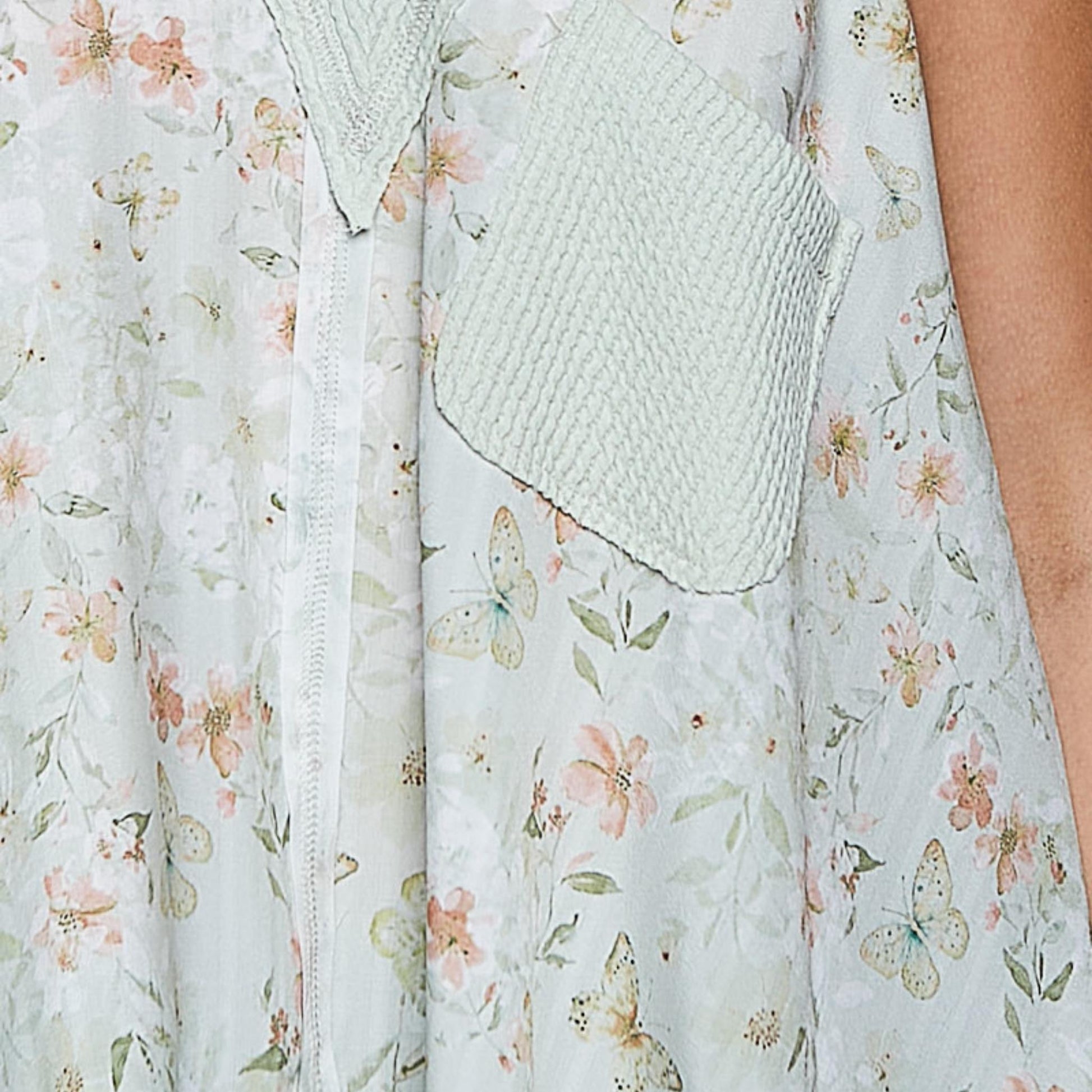 Close-up detail of the front pocket and V-neckline on the sage floral tank.