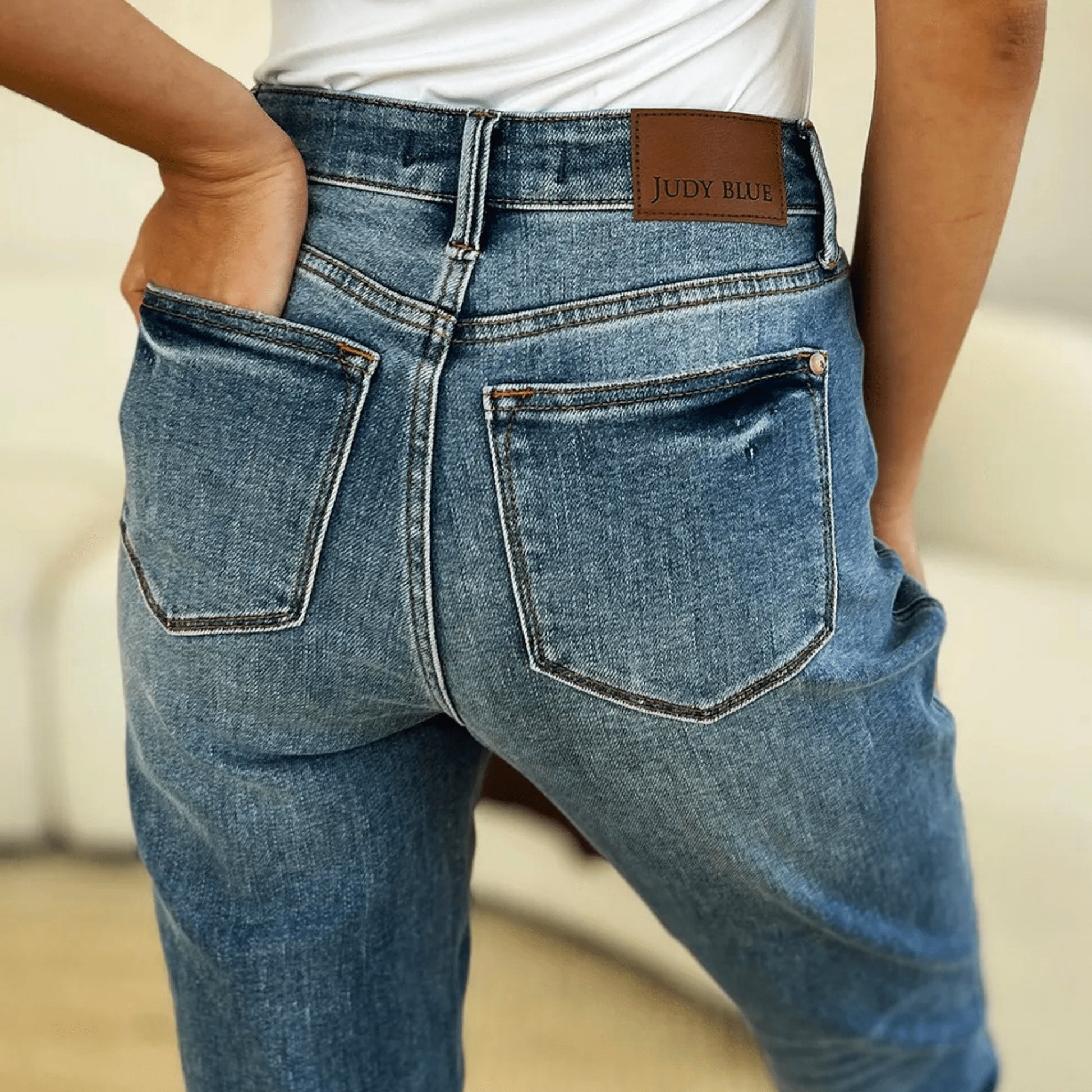 Close-up view of the magic release hem detail on medium wash denim.