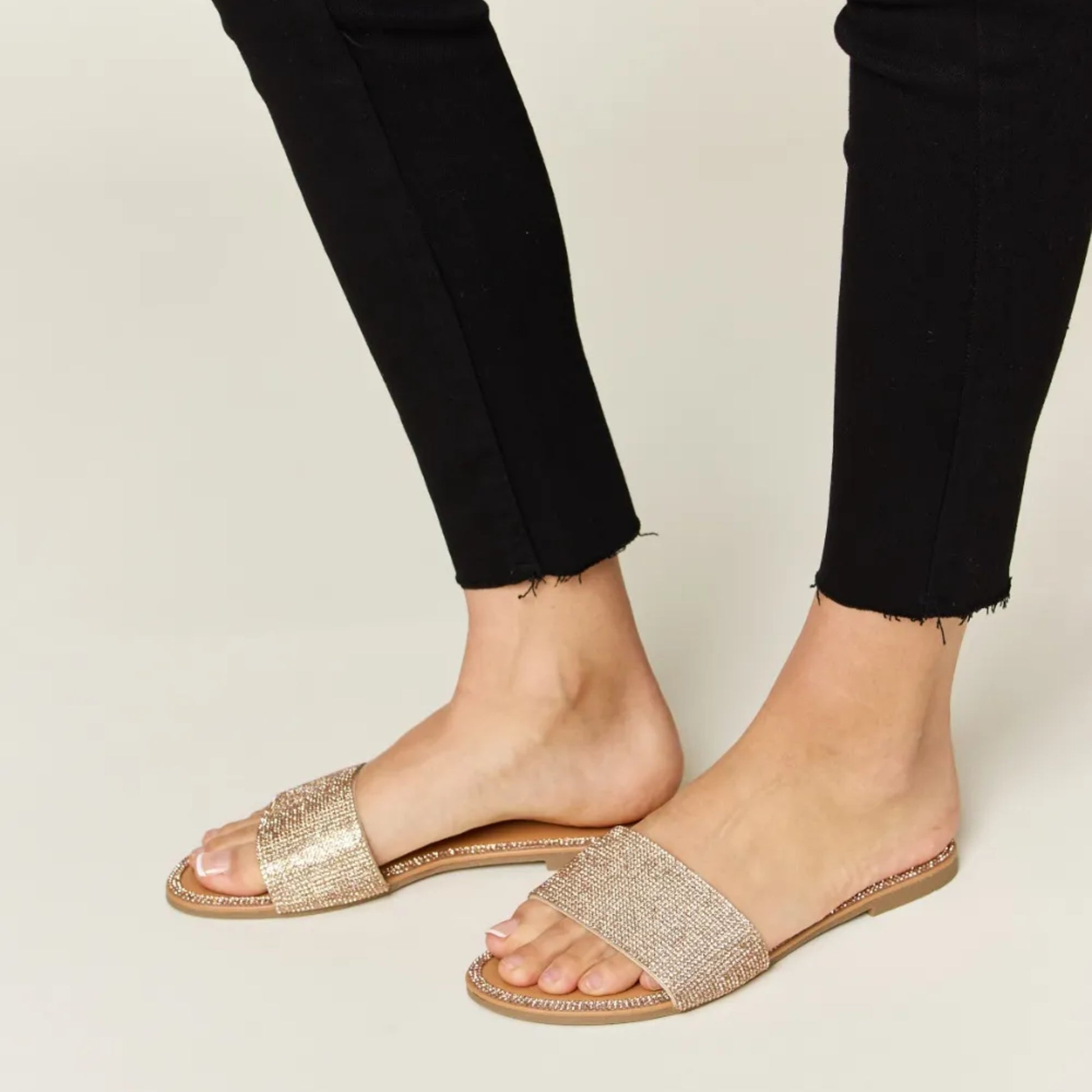 Side profile of rose gold flat sandals highlighting the 0.5-inch low heel.