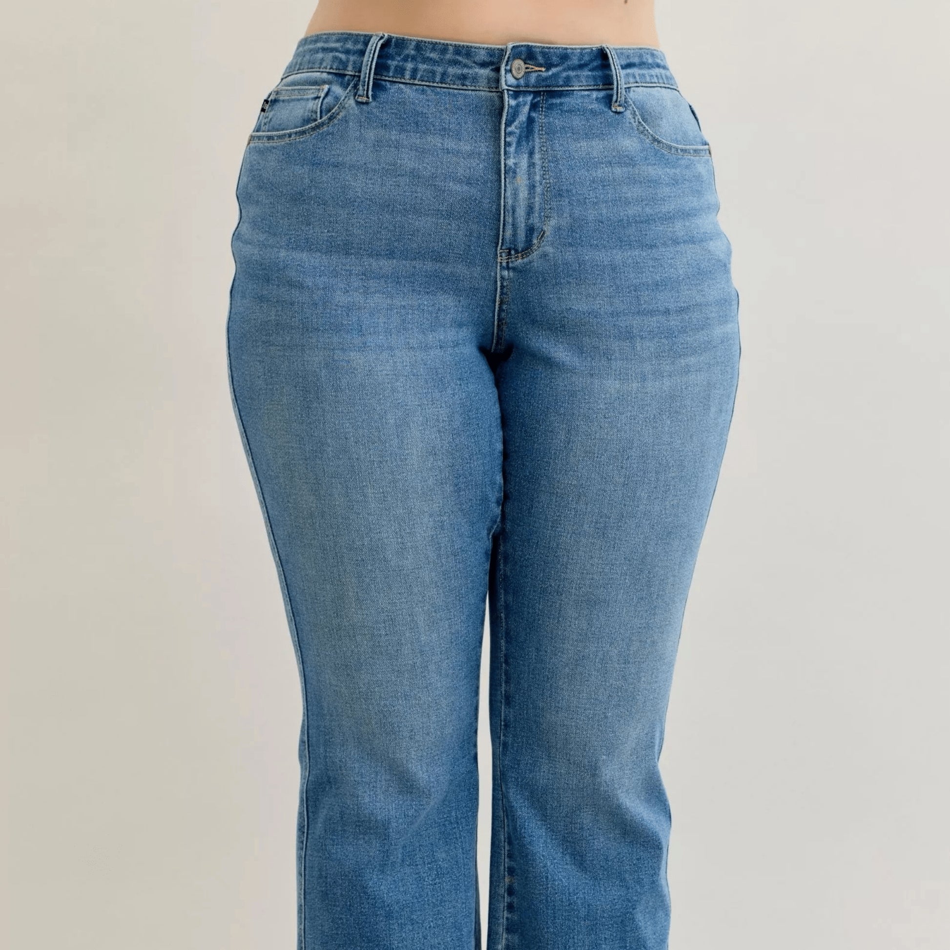 Detail view of the mid-rise waist and slim bootcut leg on Judy Blue jeans.