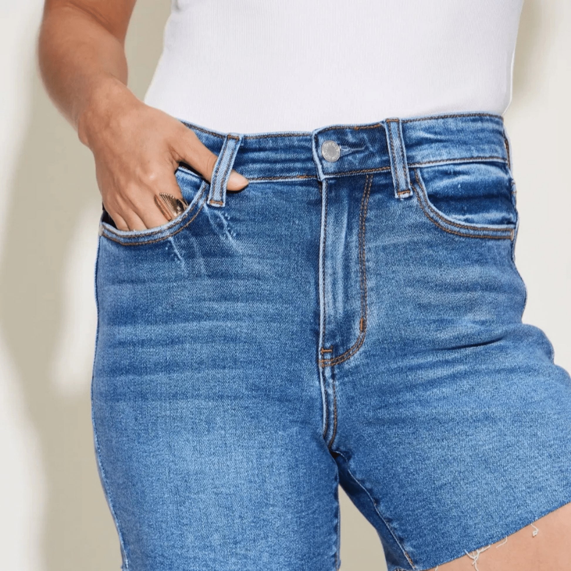 Detailed shot of high-waist slim shorts in medium wash.