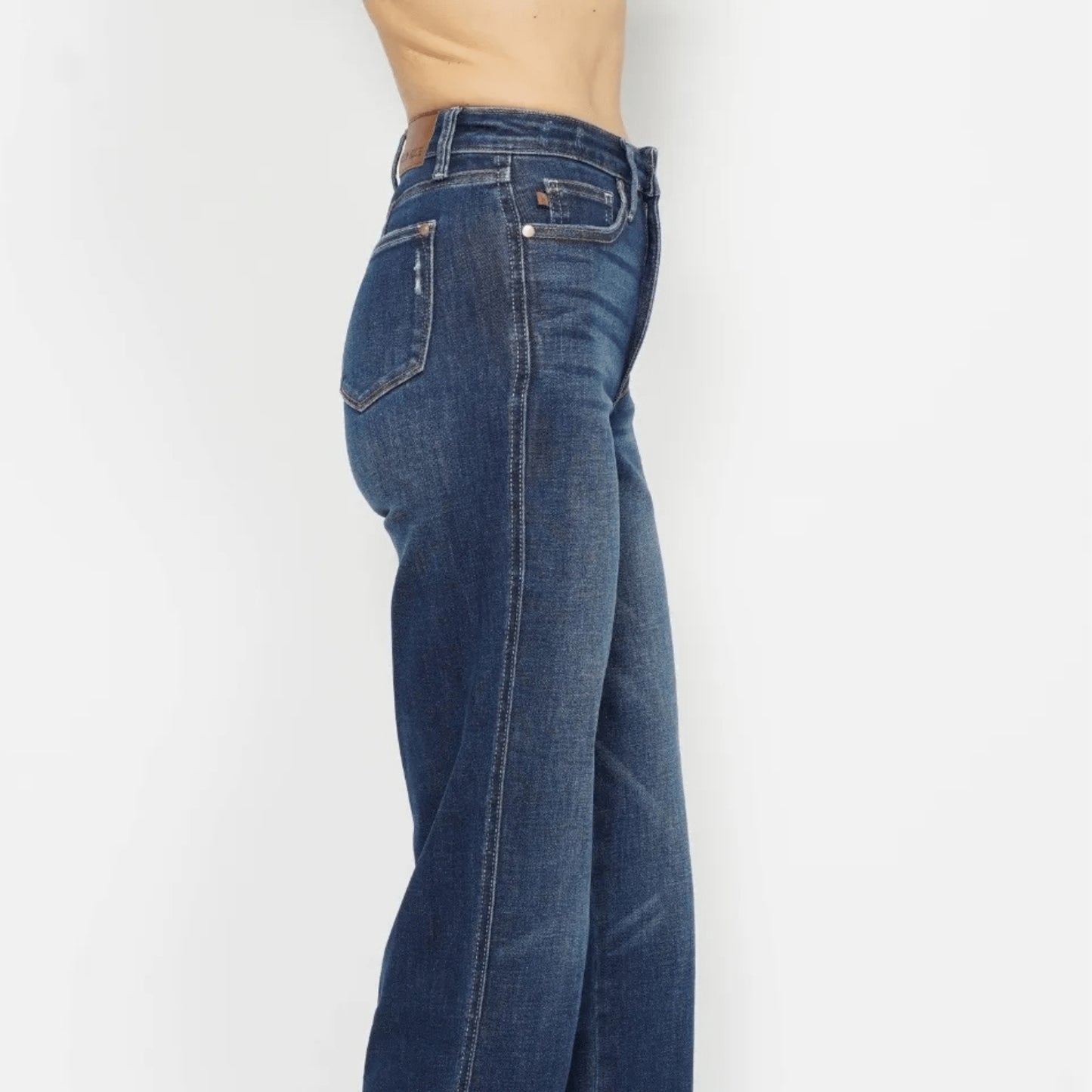 Close-up of the smoothing tummy control waistband on dark wash jeans.