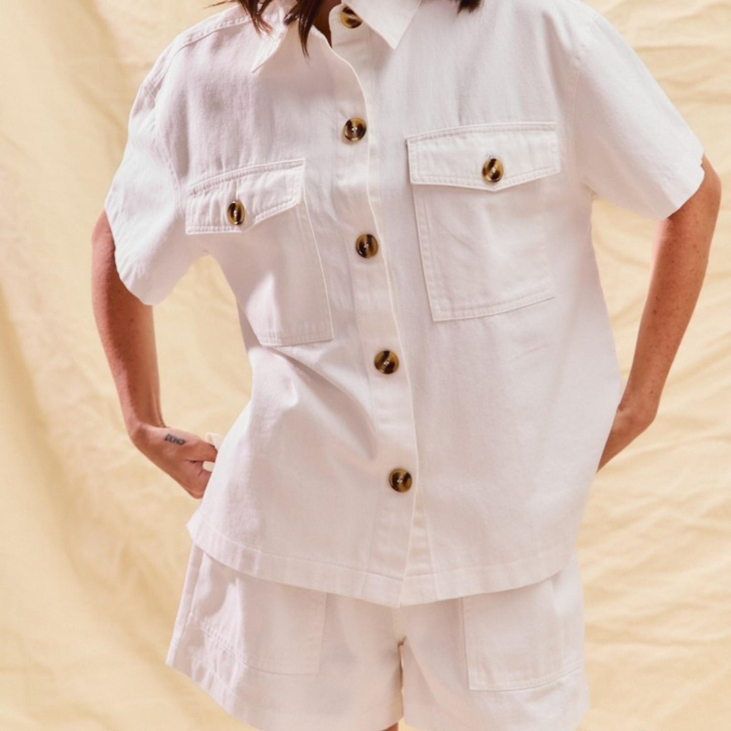 Lifestyle view of the SO ME denim two-piece set in off-white.