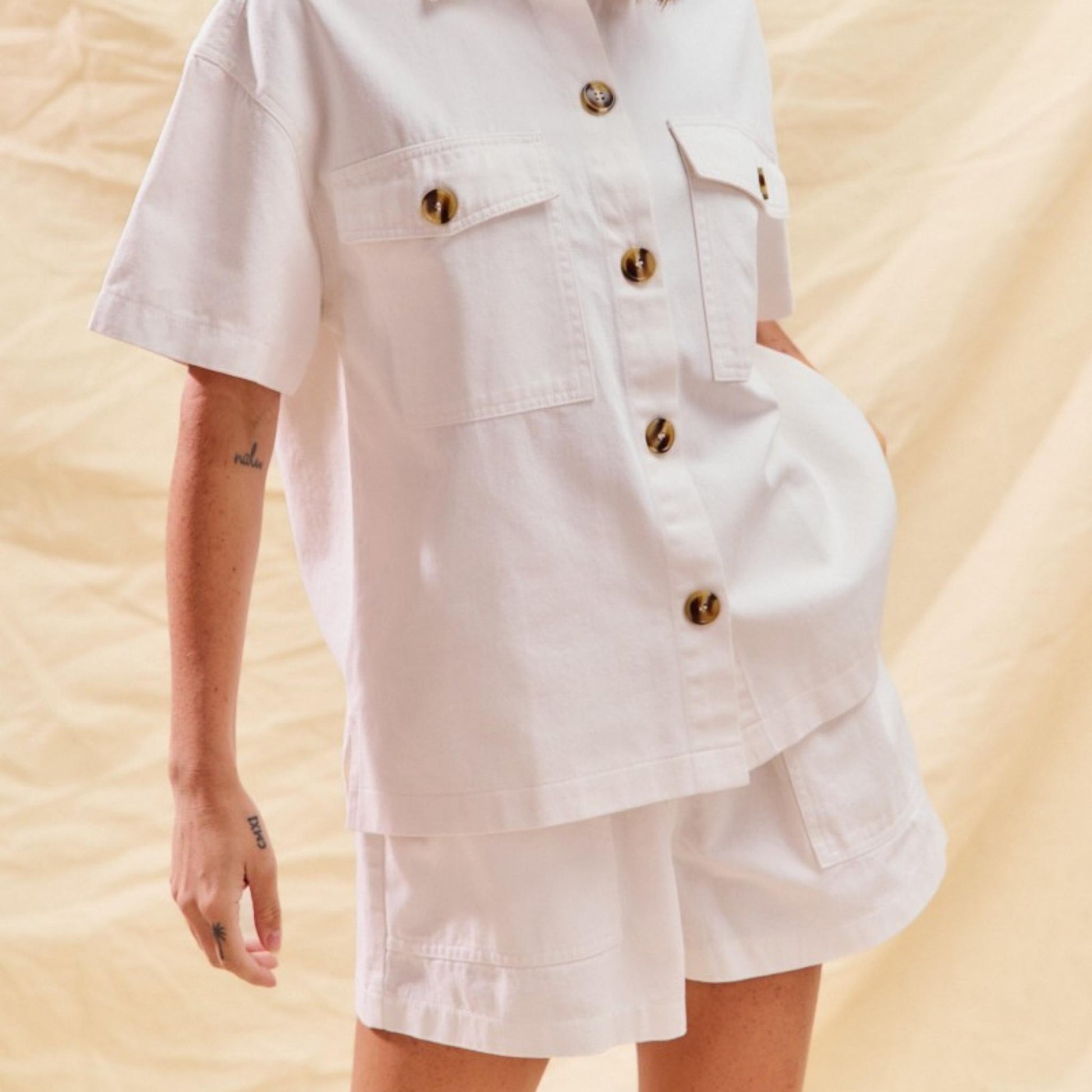Full view of the SO ME off-white denim button-down top and matching shorts set.