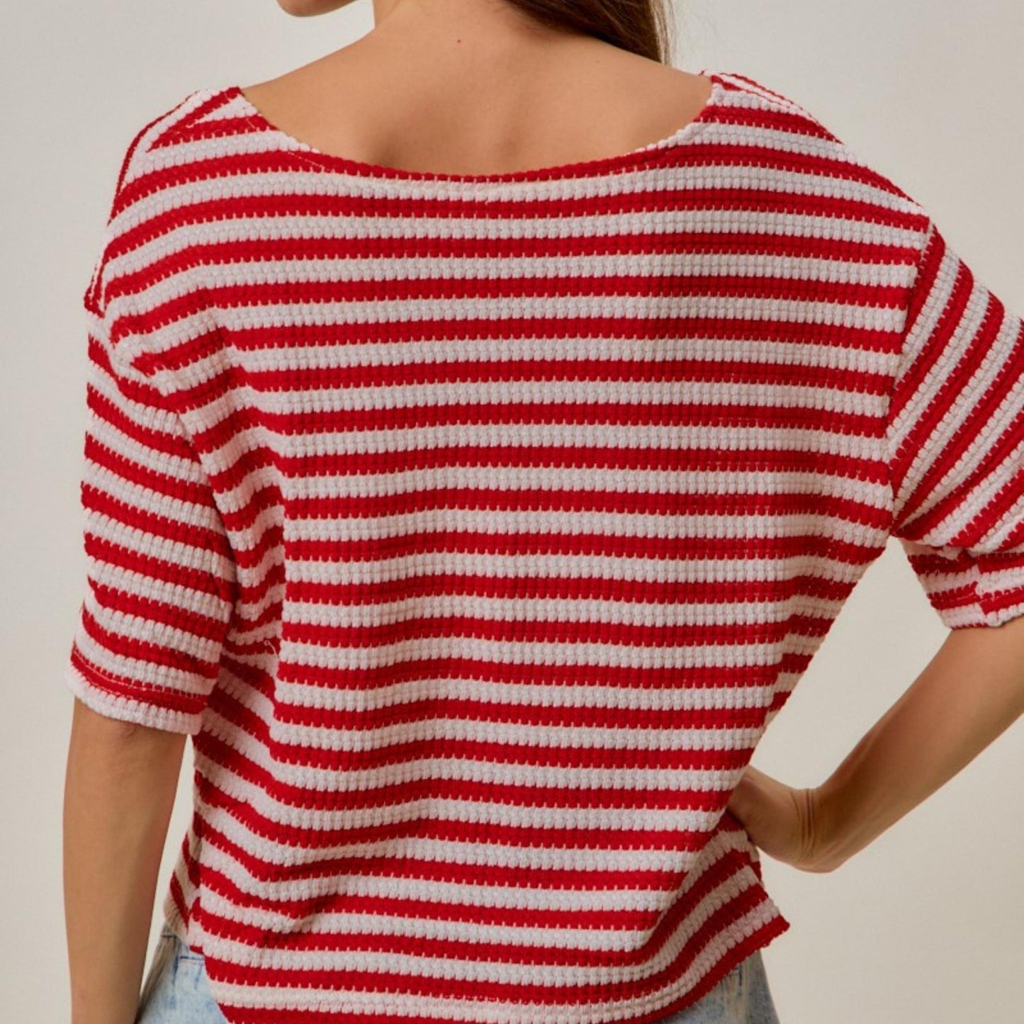 Flat lay view of the SO ME red and ivory stripe waffle knit cardigan top.