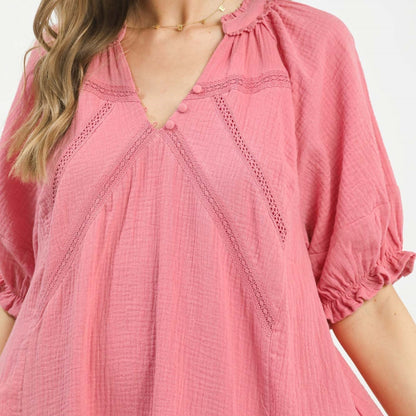 Close-up of a pink dress with intricate details on a white background