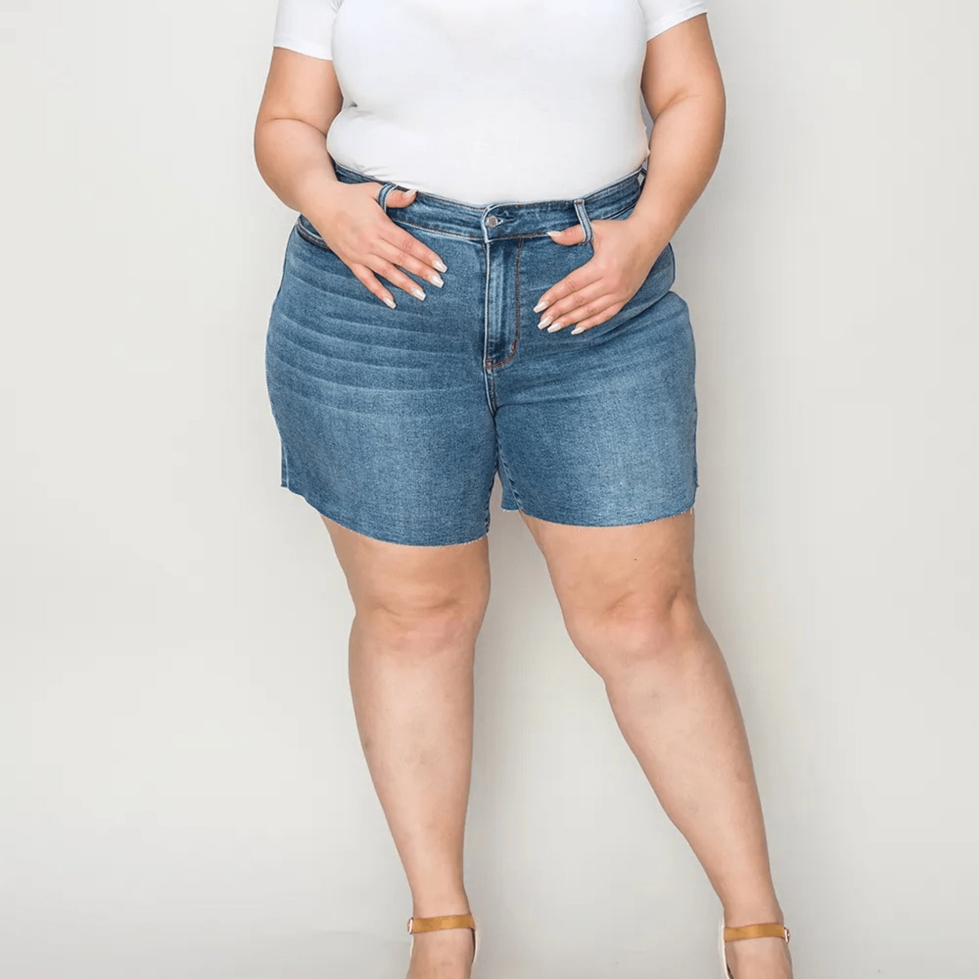 Lifestyle model shot of summer denim shorts against a plain background.