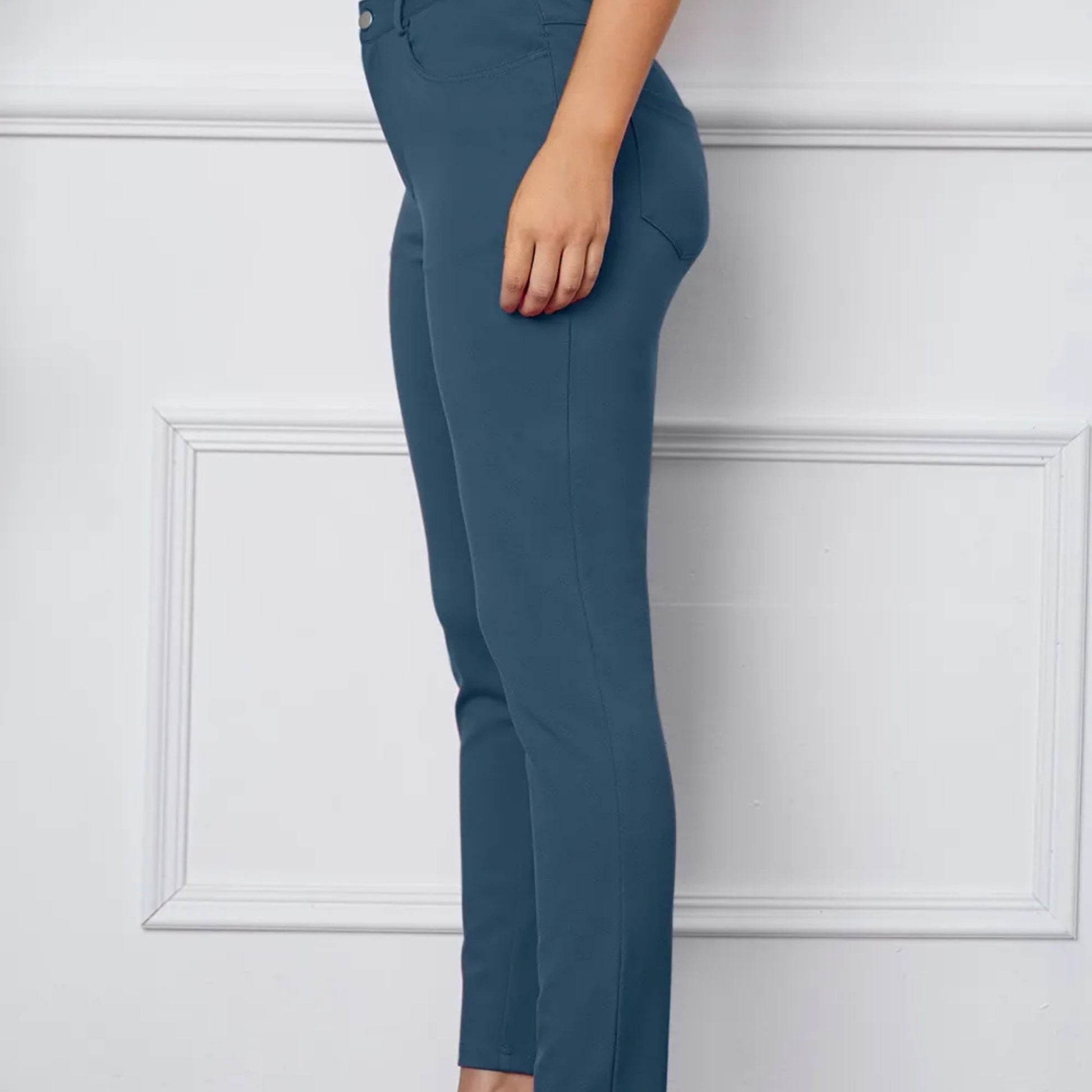 Teal pants worn by a person on a white background