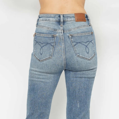Close-up showing the stretch and texture of the medium wash embroidered denim.