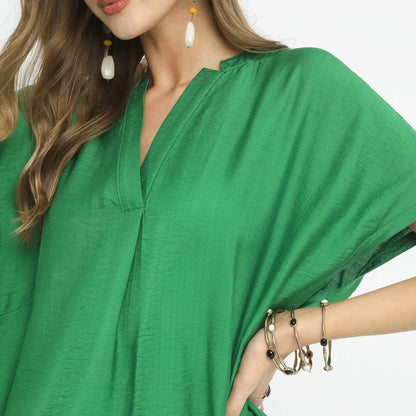 Close-up of the textured rayon fabric and classic V-neckline on the Umgee Apple Green blouse.