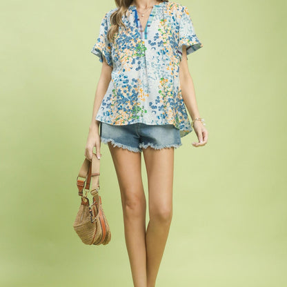 Lifestyle shot of the Umgee flutter sleeve top styled with denim for a summer outfit.
